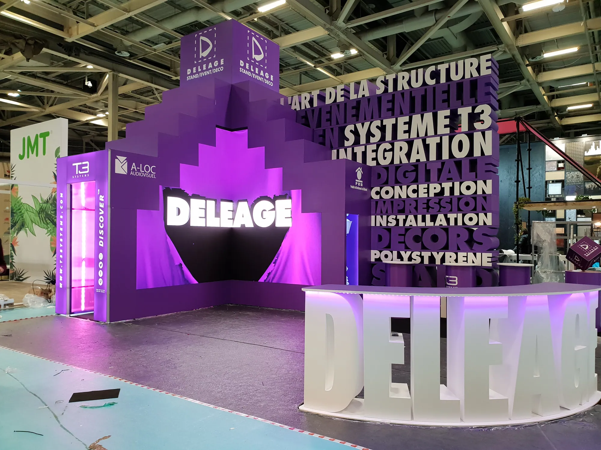 Custom exhibition stand with 3D lettering and LED-lit stepped feature wall