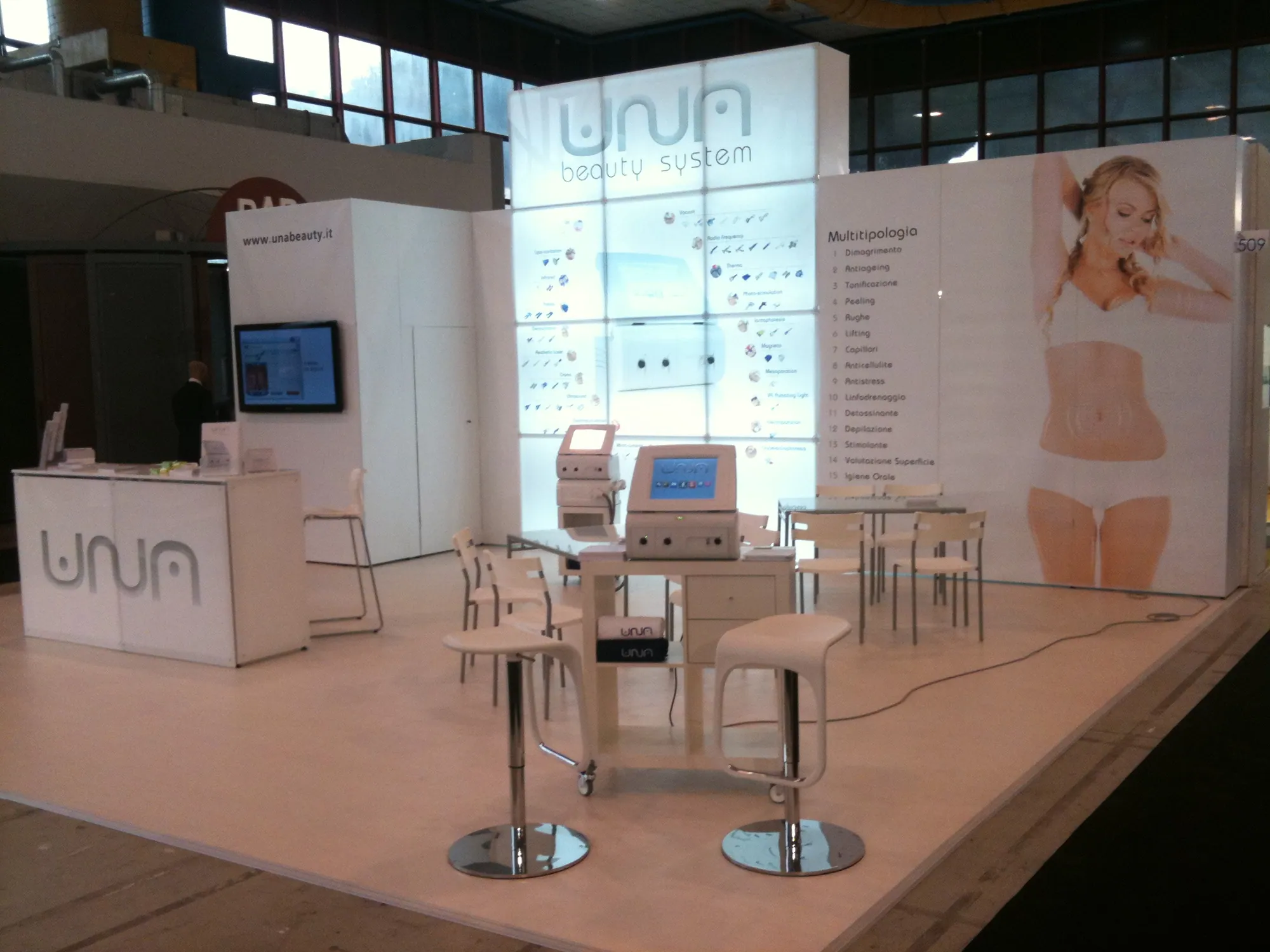 White beauty-brand stand with backlit product wall built with T3