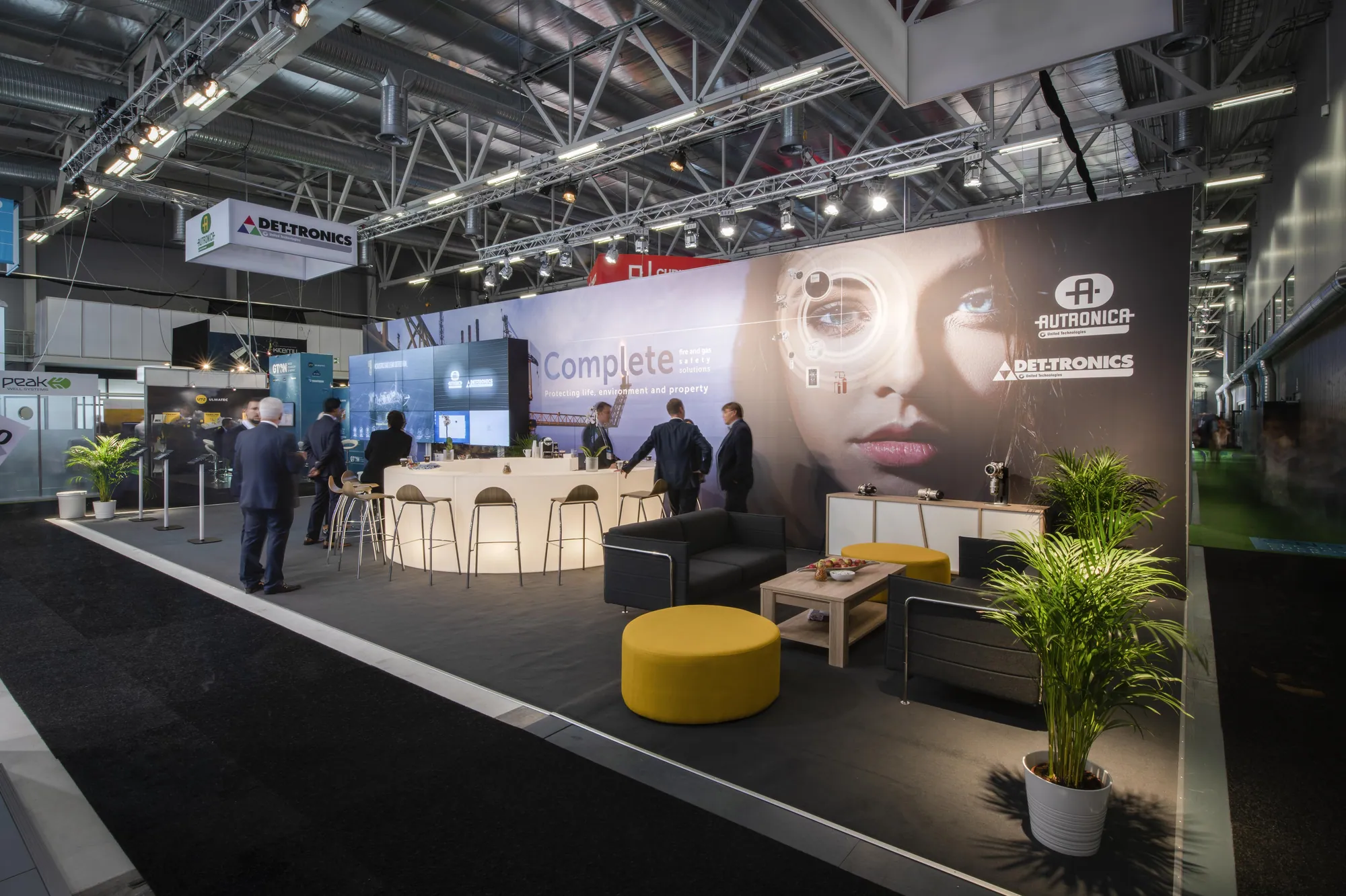 Custom exhibition stand with bar, lounge seating and large-format graphic wall