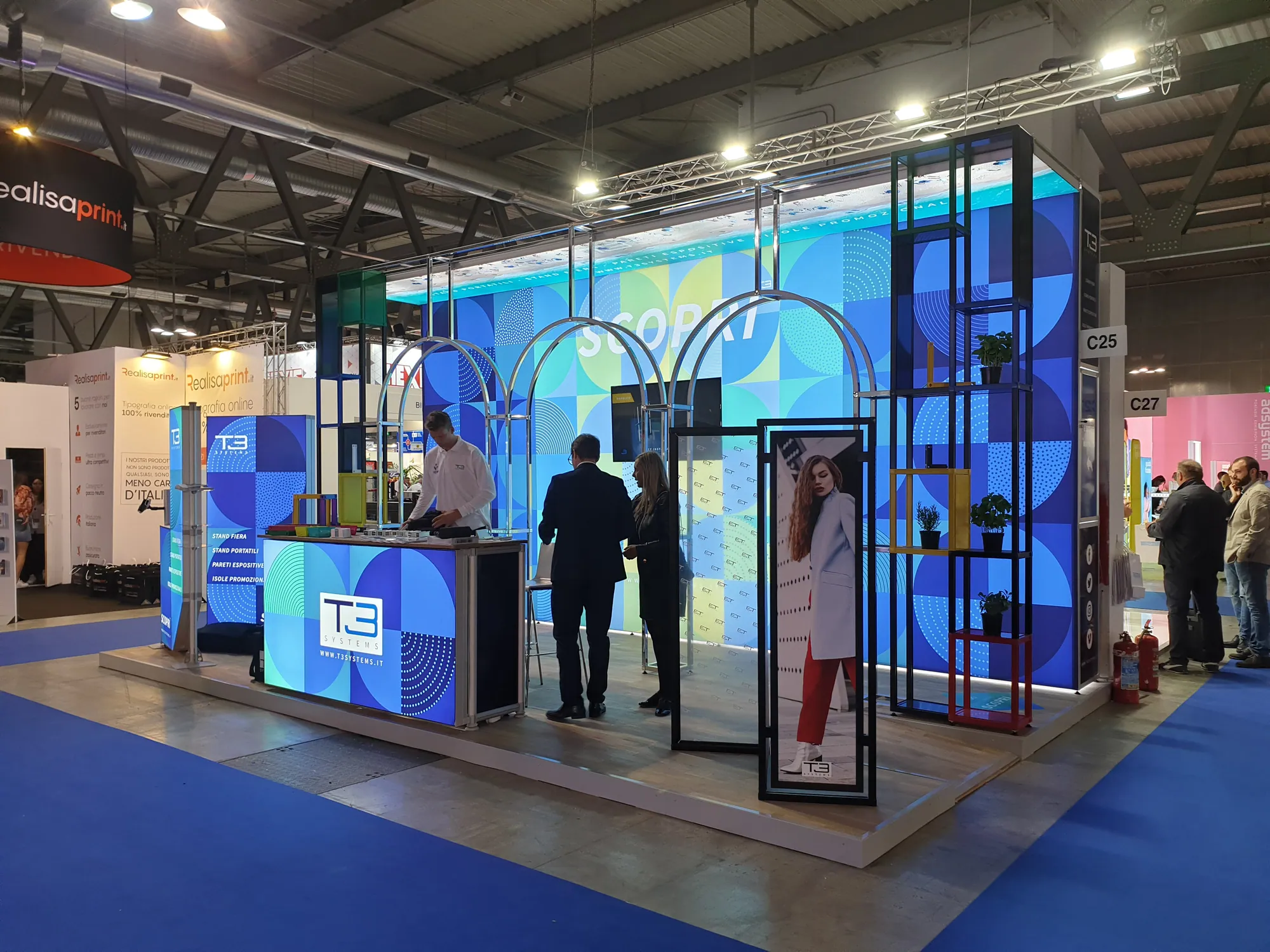 Custom T3 exhibition stand with arches, open shelving and lightbox graphics
