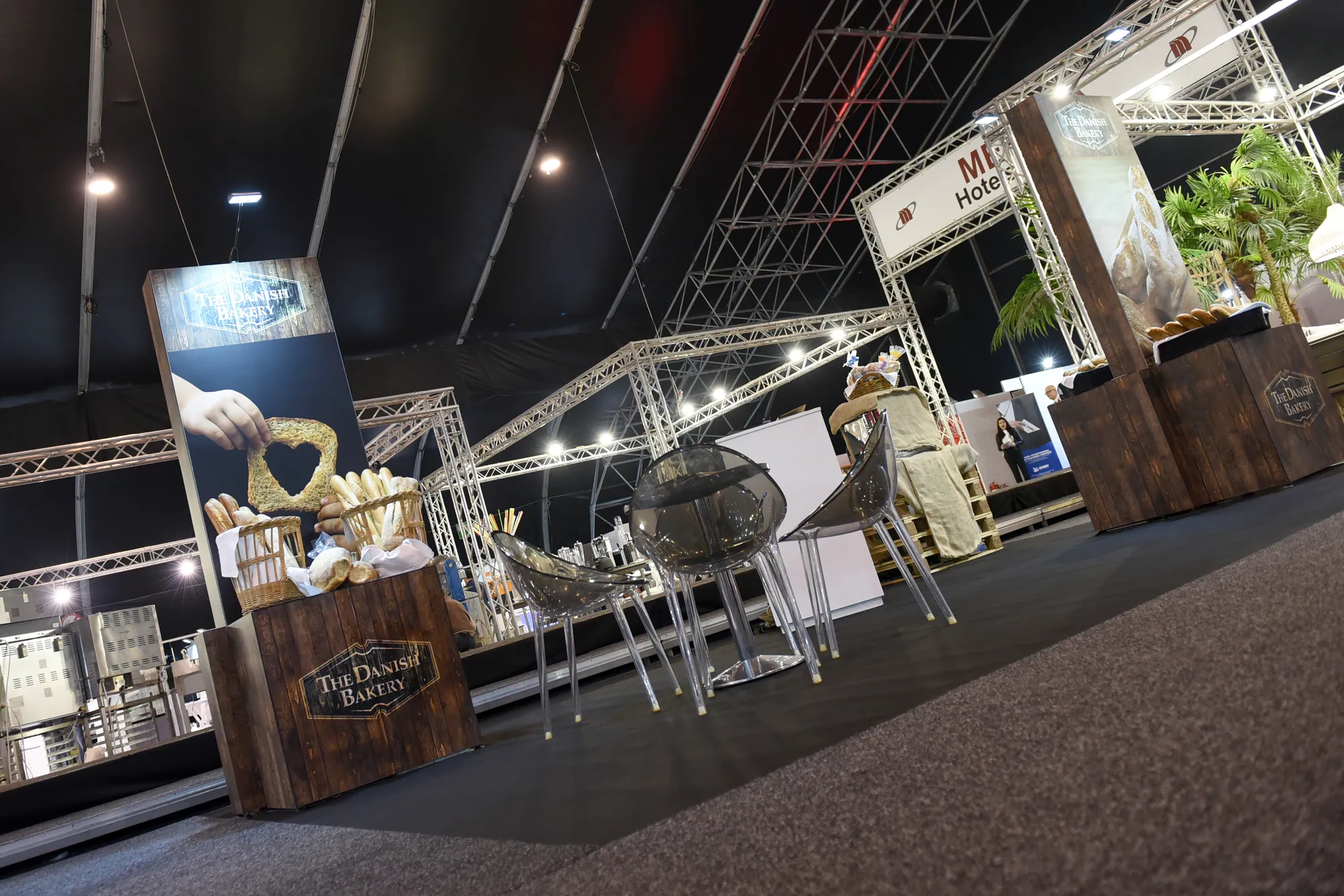 Timber-effect bakery display and seating area at a food show