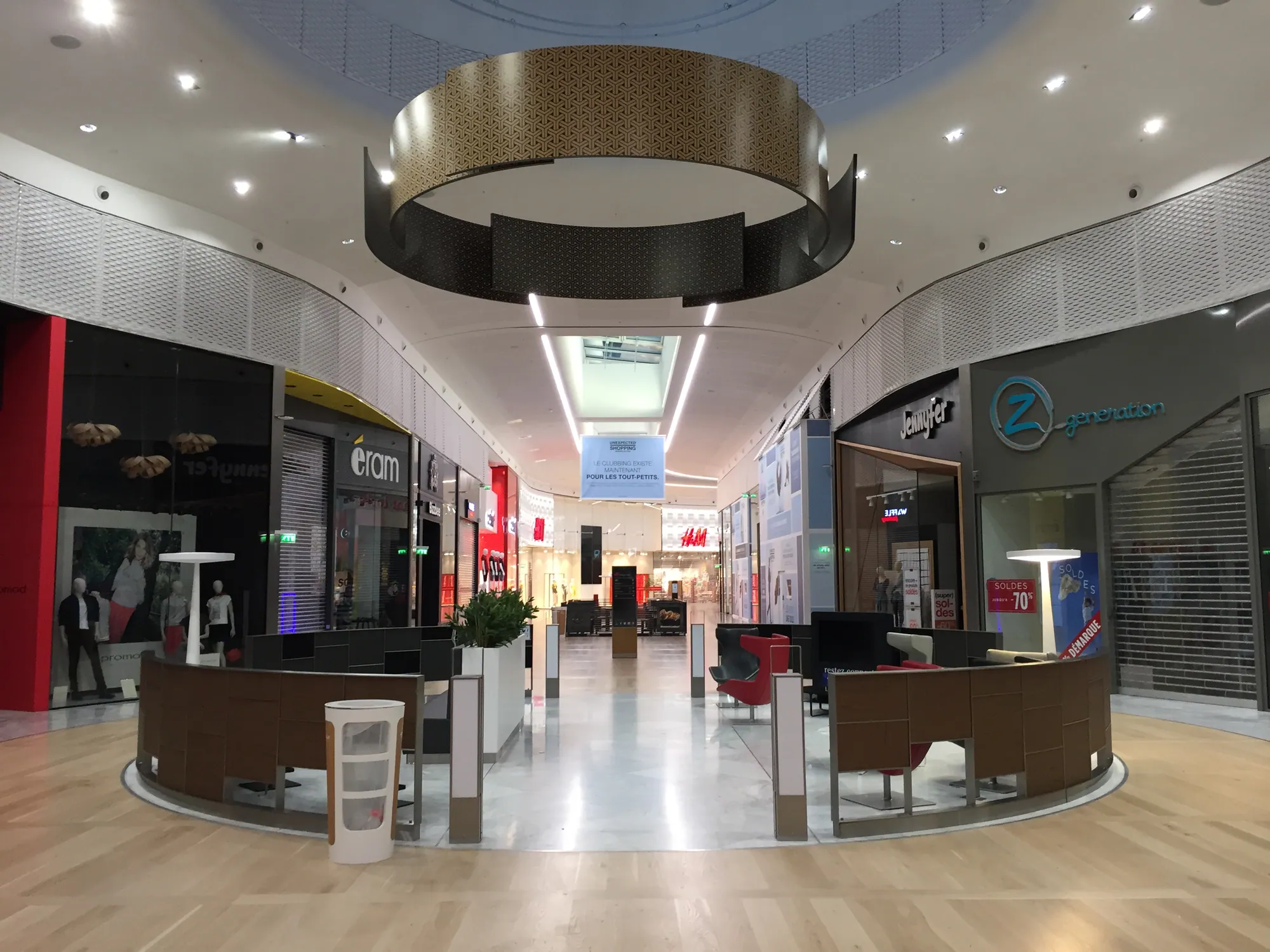 Suspended circular ring structure above reception kiosks in a shopping centre