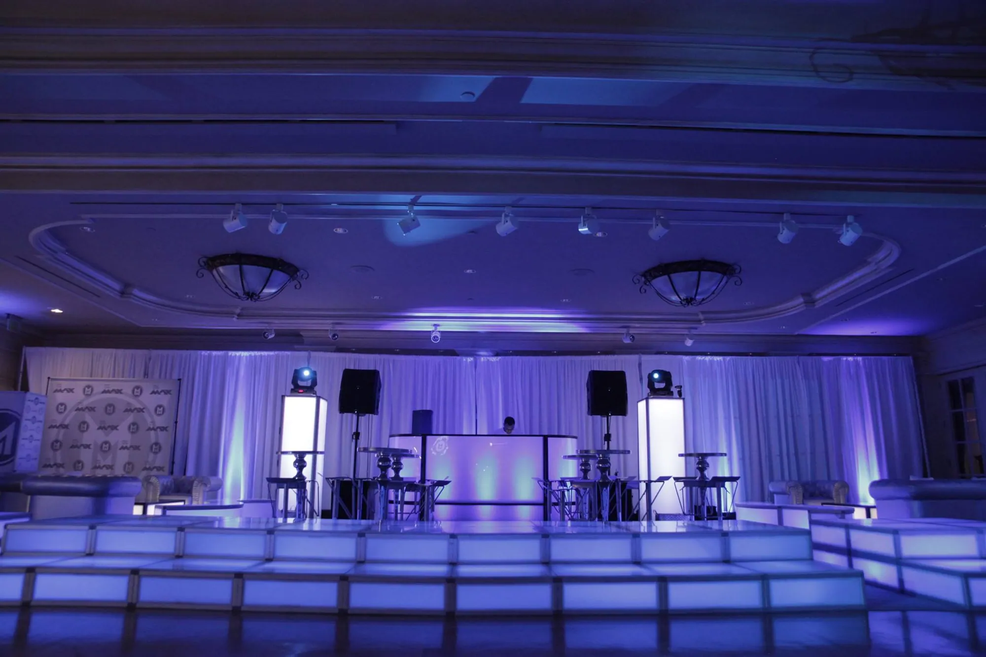 White illuminated stage and modular lounge seating built with T3 in a ballroom