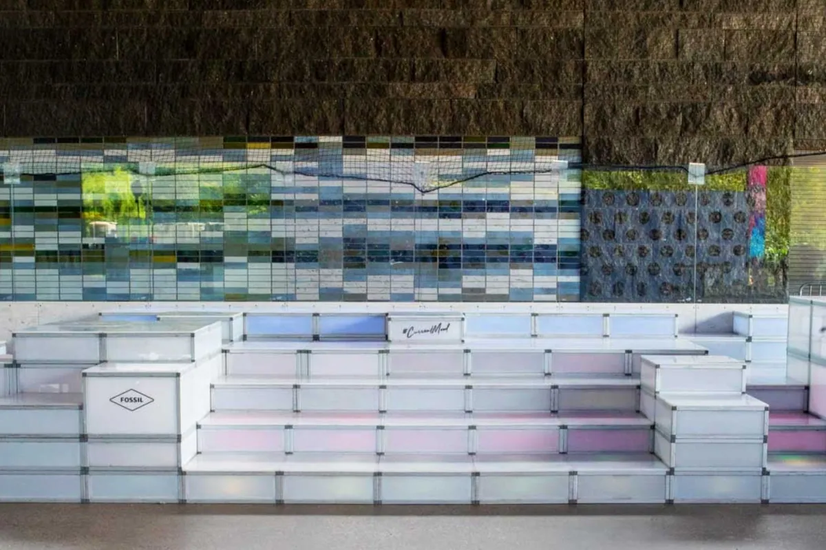 White modular tiered seating built with T3 in front of a stone feature wall