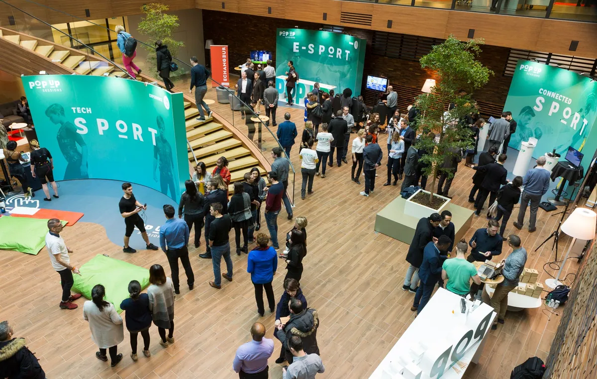 Curved fabric graphic walls built with T3 at a busy tech event atrium