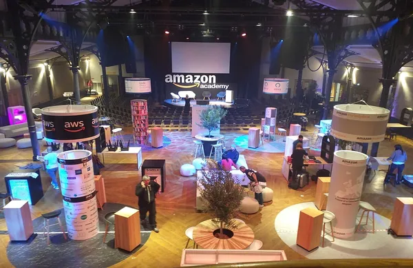 Conference event space with branded towers, lounge seating and stage set