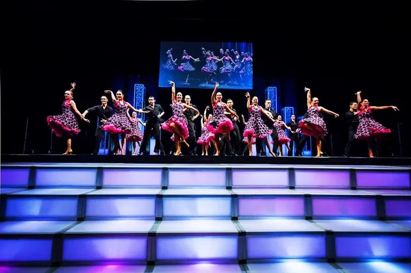 Dance troupe performing on a tiered LED-lit stage built with T3