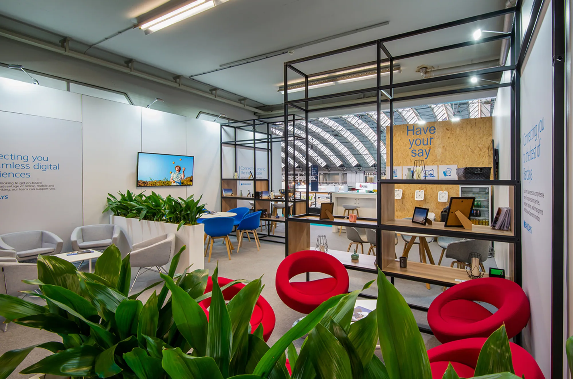 Lounge area framed by black T3 Deco shelving and planting
