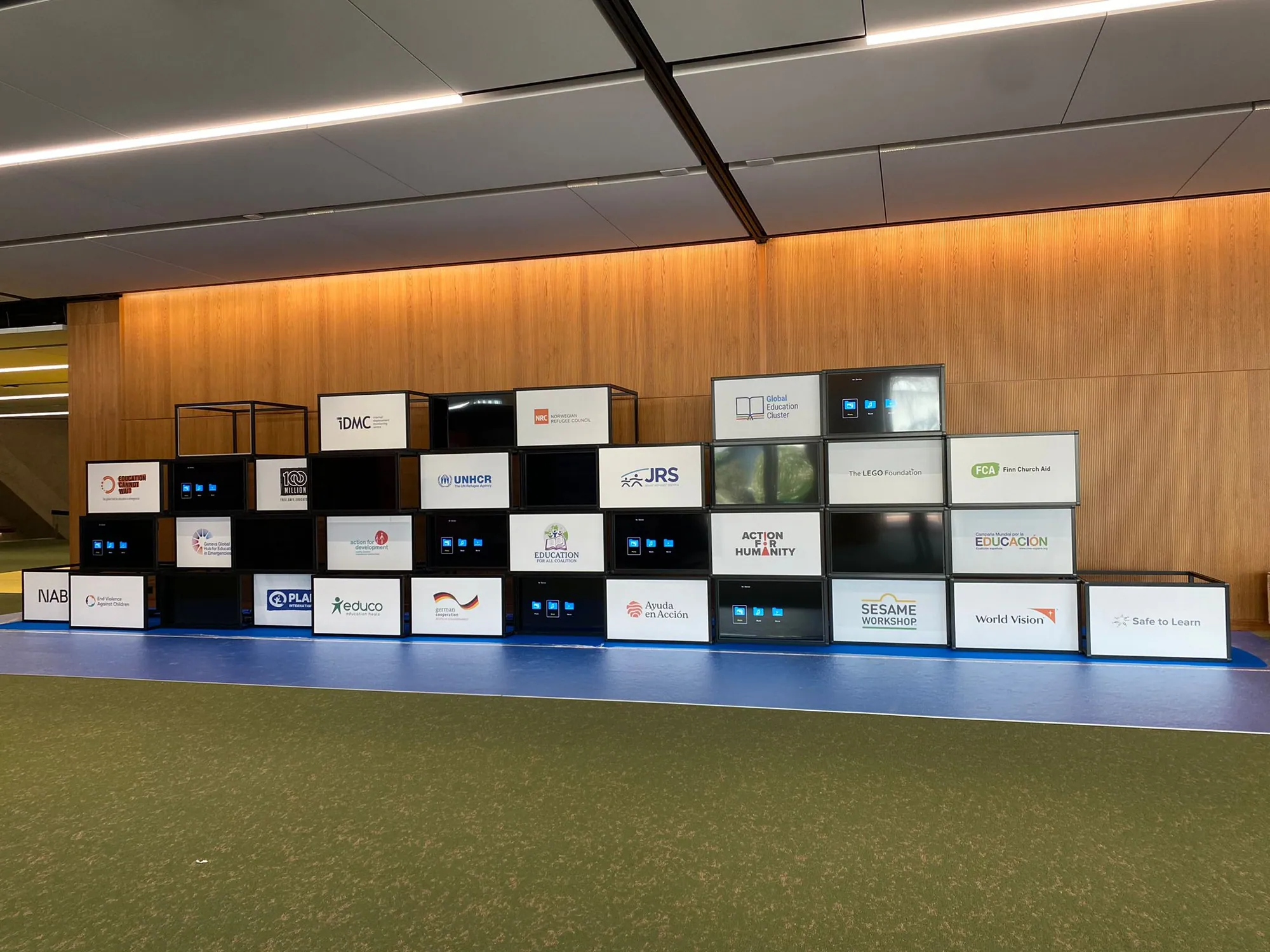 Stacked black T3 Deco cube wall with printed partner logo panels