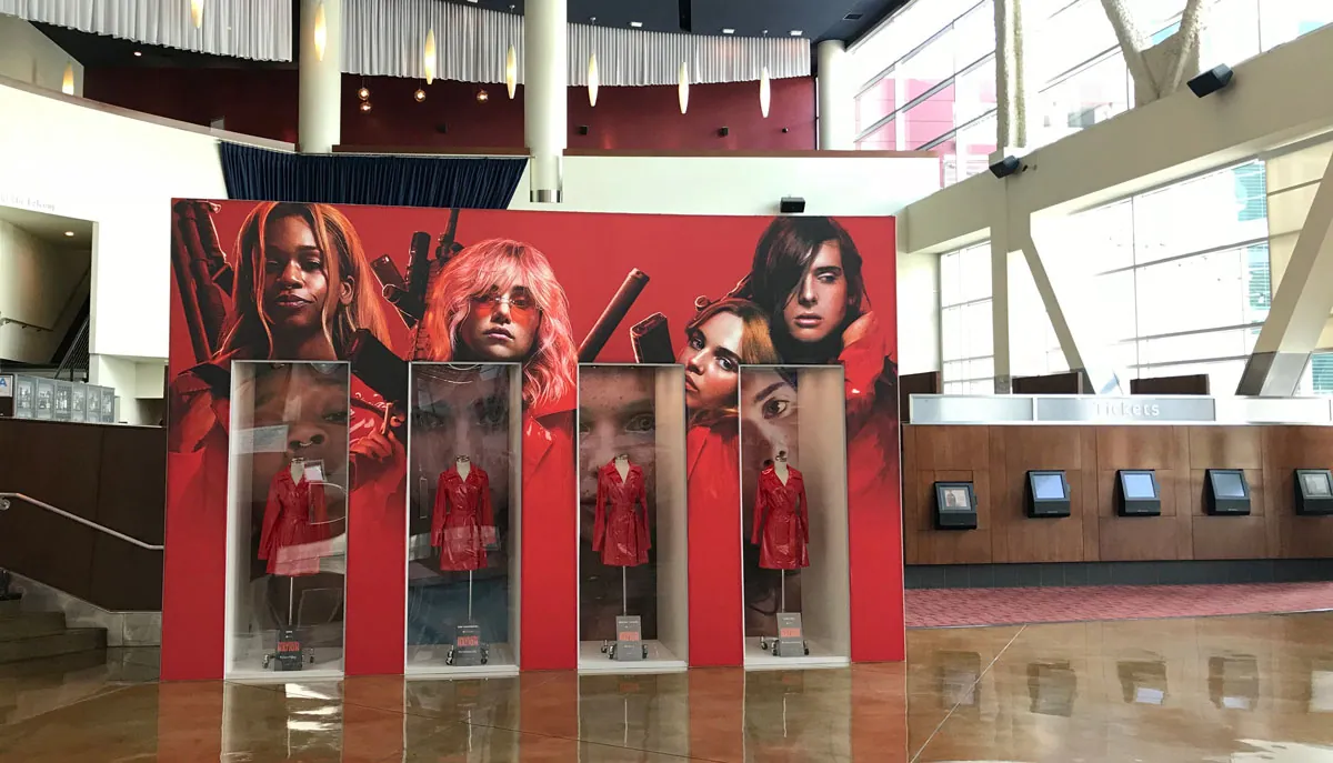 Row of costume display cabinets set into a large graphic wall