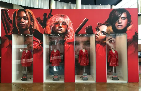 Front view of glazed costume display cabinets in a graphic wall