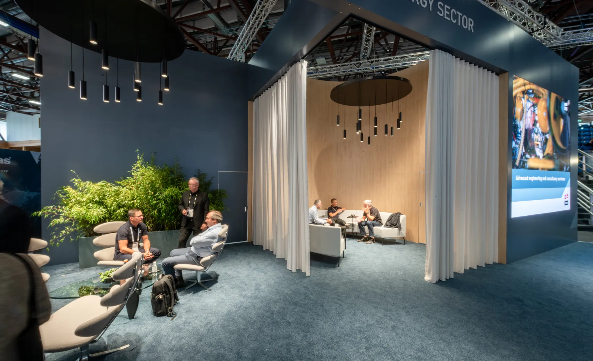 Custom stand lounge with curtained meeting room and planting