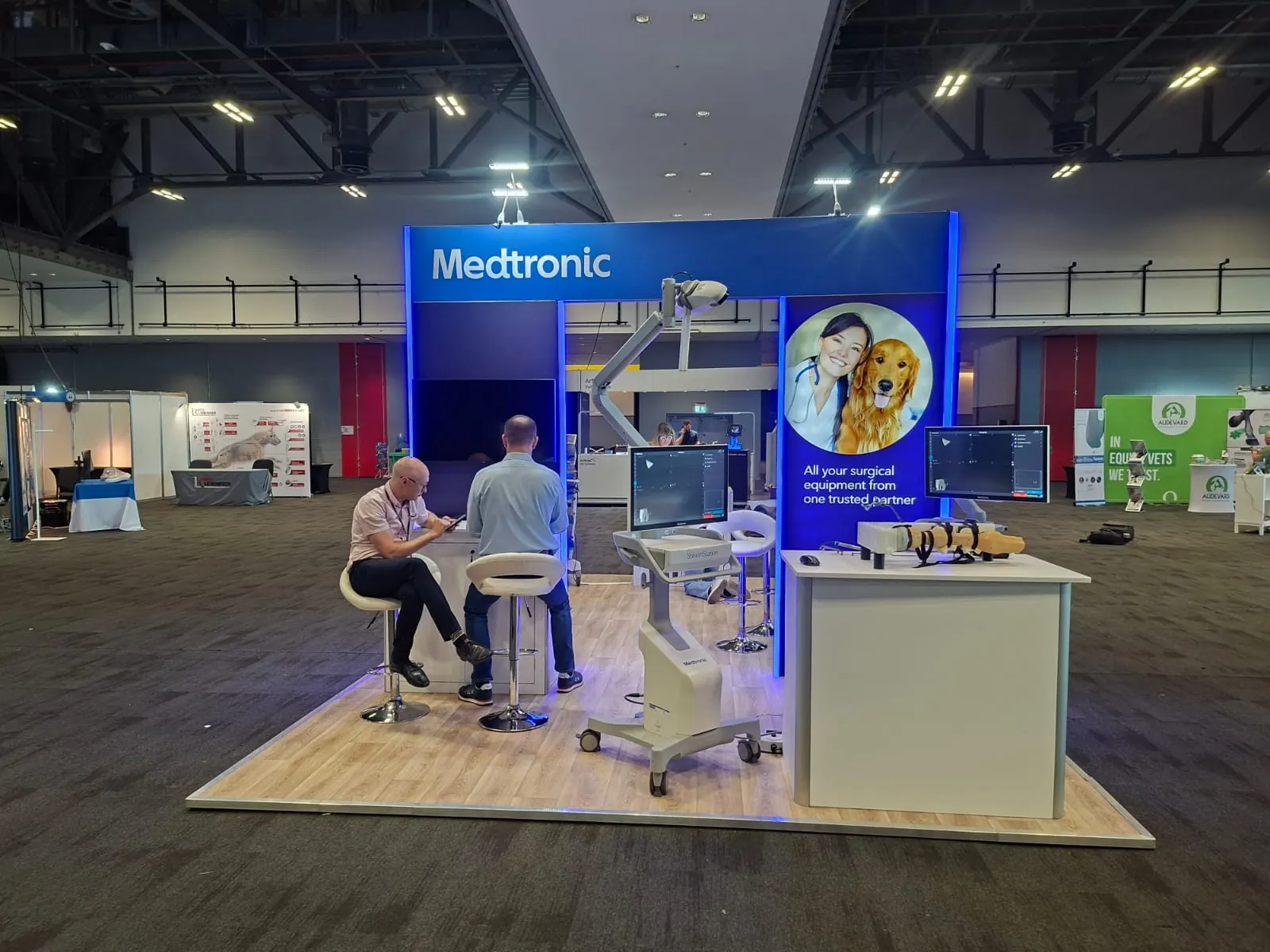 Medtronic stand at ECVS 2026: island stand with a blue wall, a counter and clinicians at a demonstration station