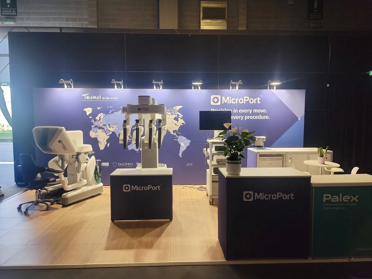 MicroPort stand at ERUS 2026: blue wall with a world map, a demonstration system and a black branded counter