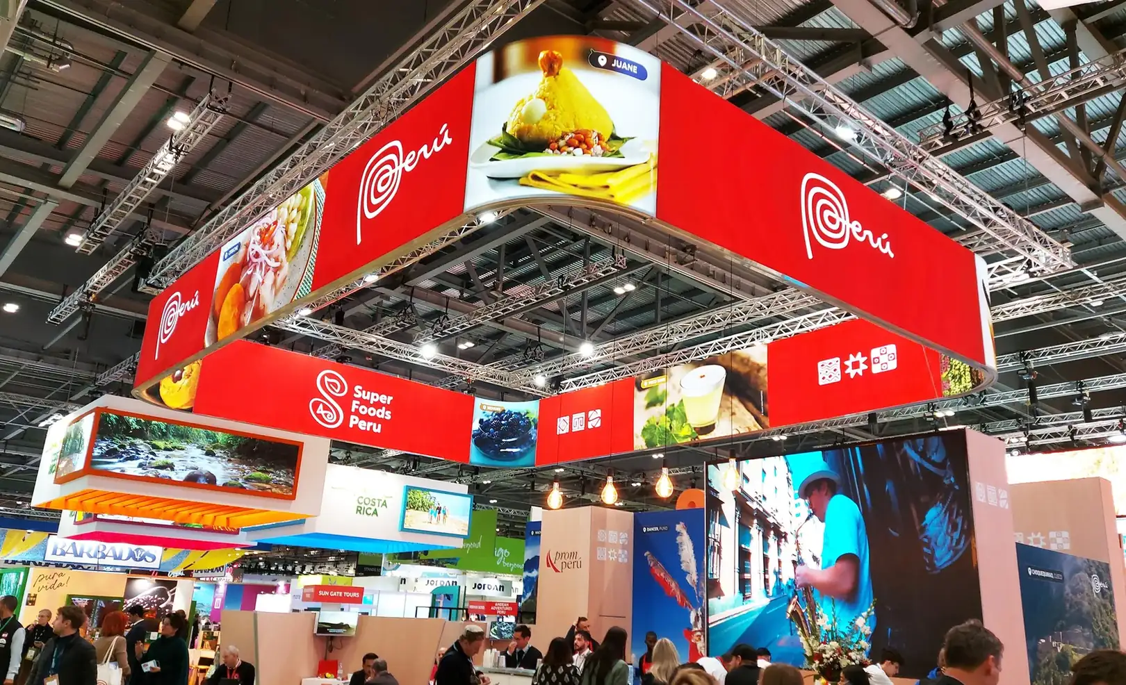 Suspended branded banner structure above a busy national pavilion