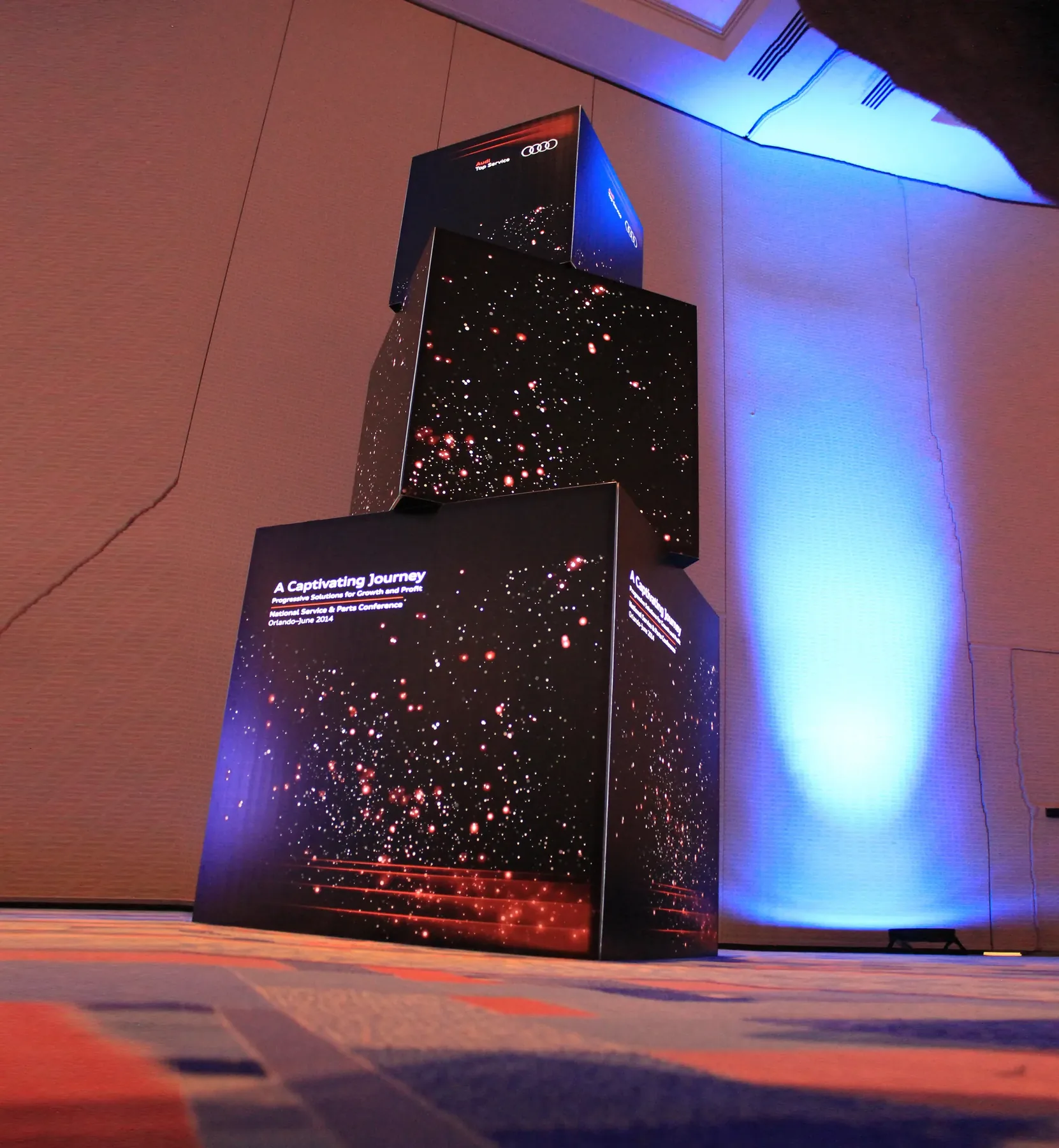Stacked black illuminated cubes built with T3 for a brand experience