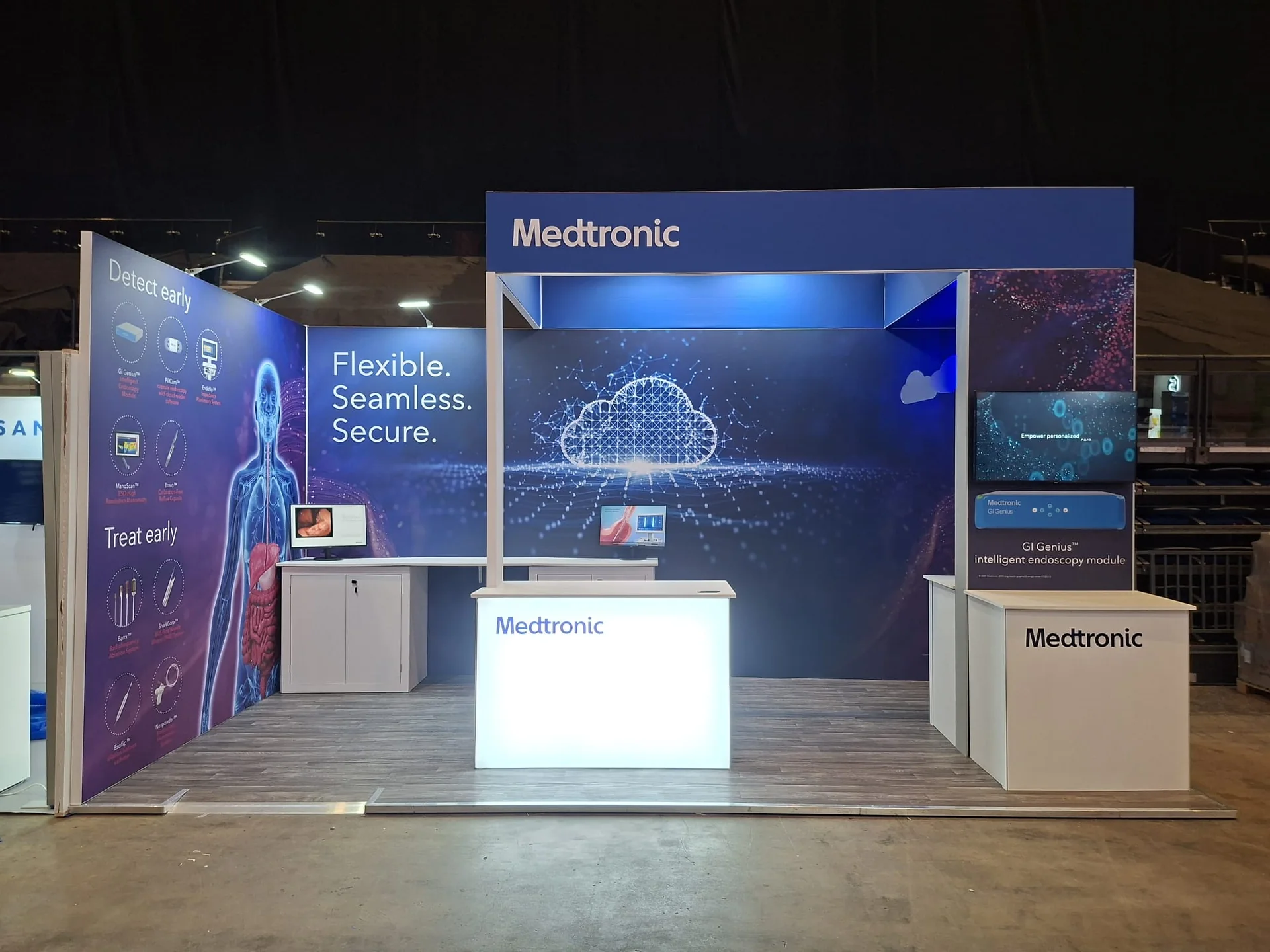 Medtronic at BSG: corner stand with blue graphic walls reading 'Flexible. Seamless. Secure.' and a lightbox counter