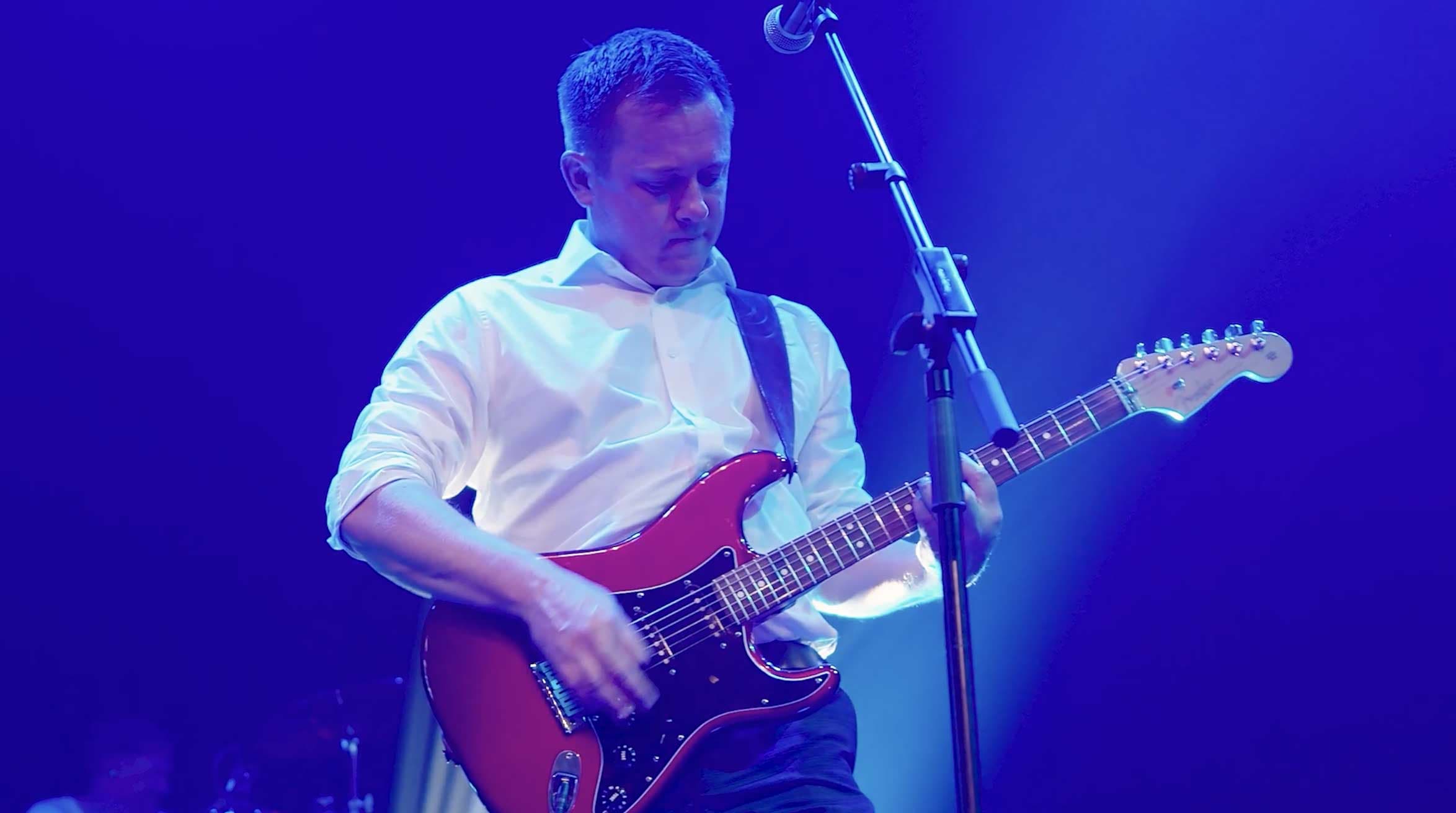 a man playing a guitar on a stage