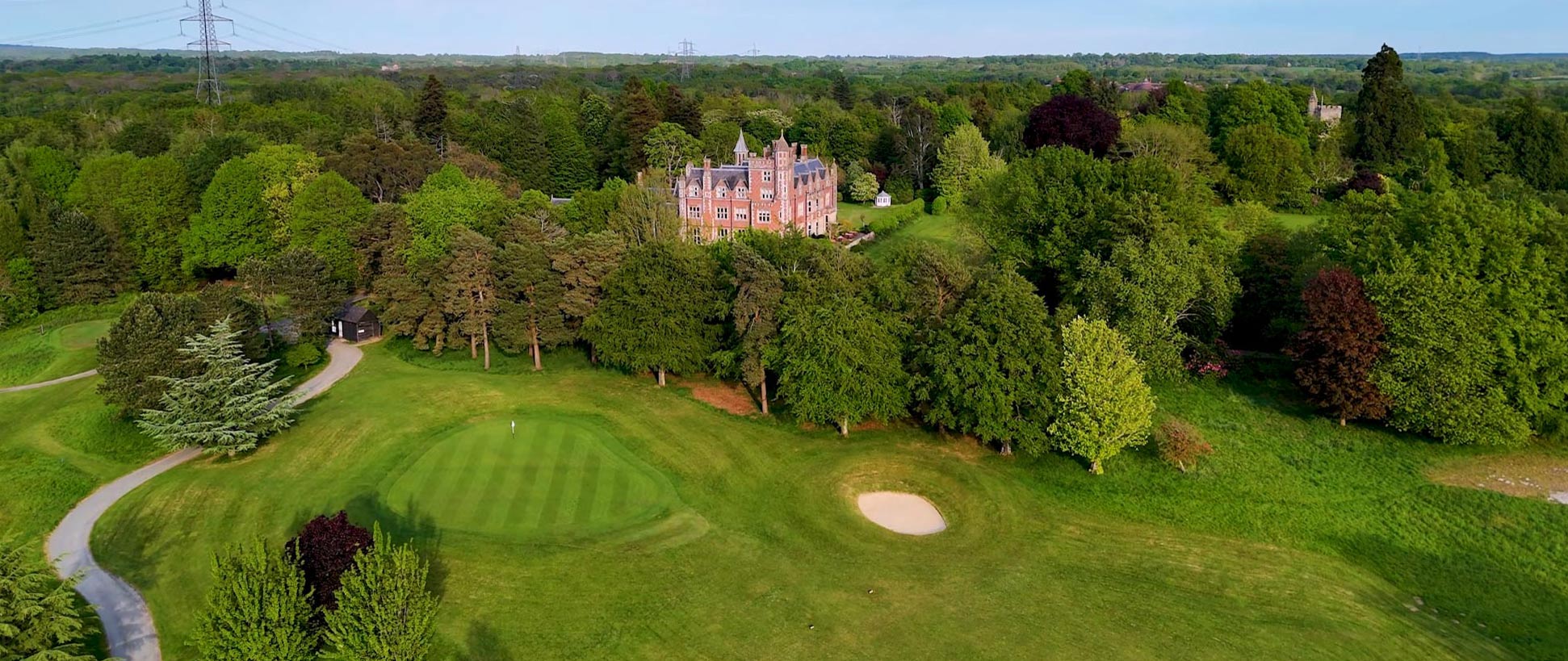 a large building with a large lawn and a golf course
