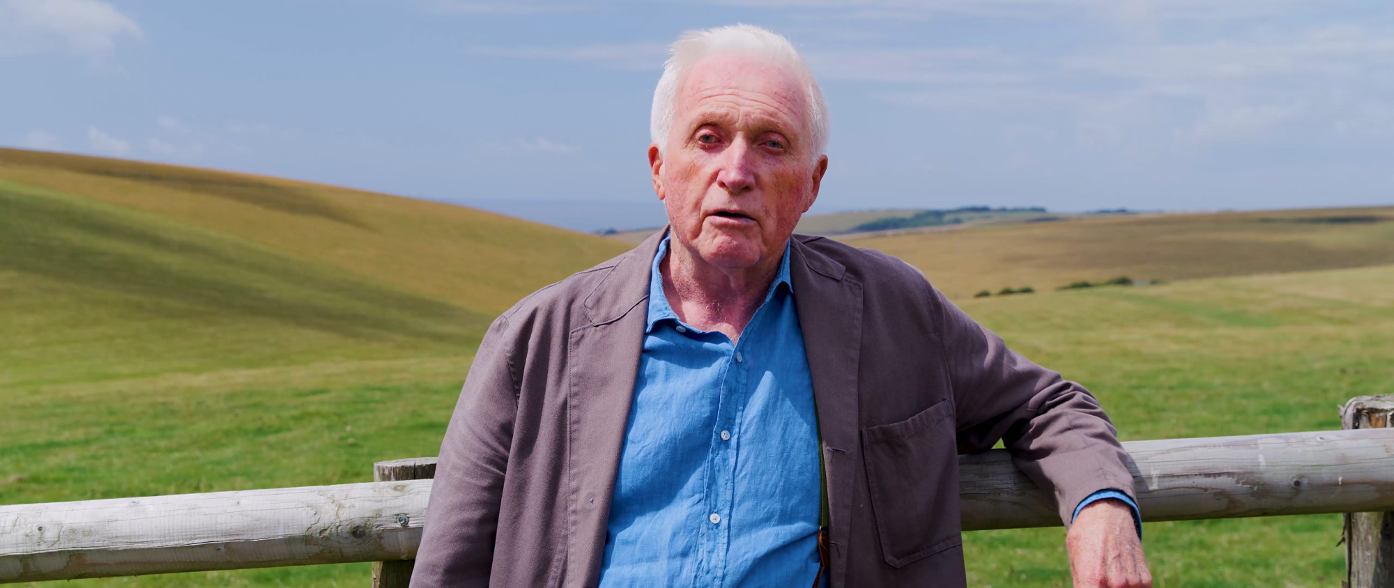 a man standing in front of a fence