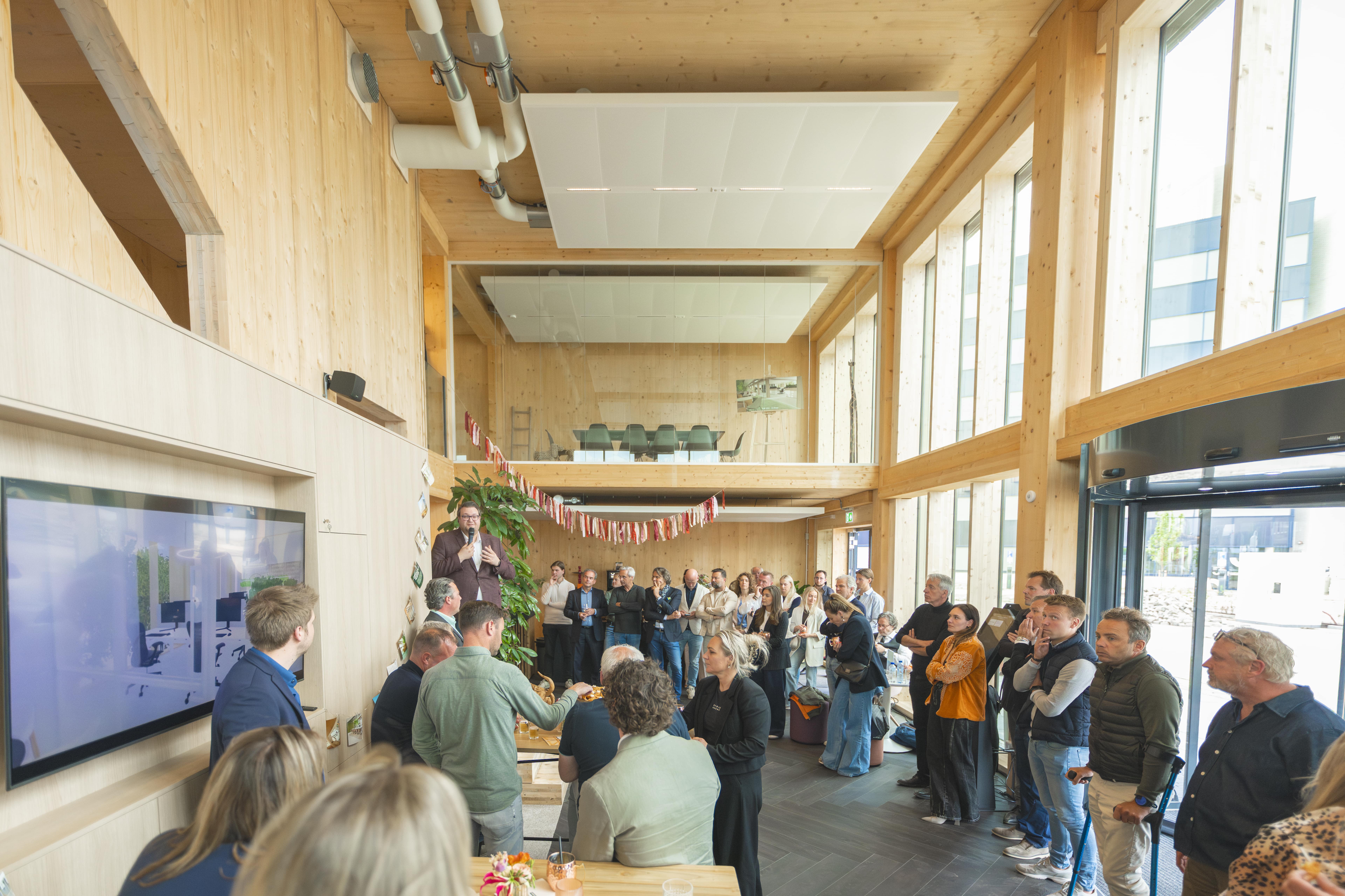 Mensen ontmoeten elkaar in de lichte entree van Campus Hambaken Timber in Den Bosch