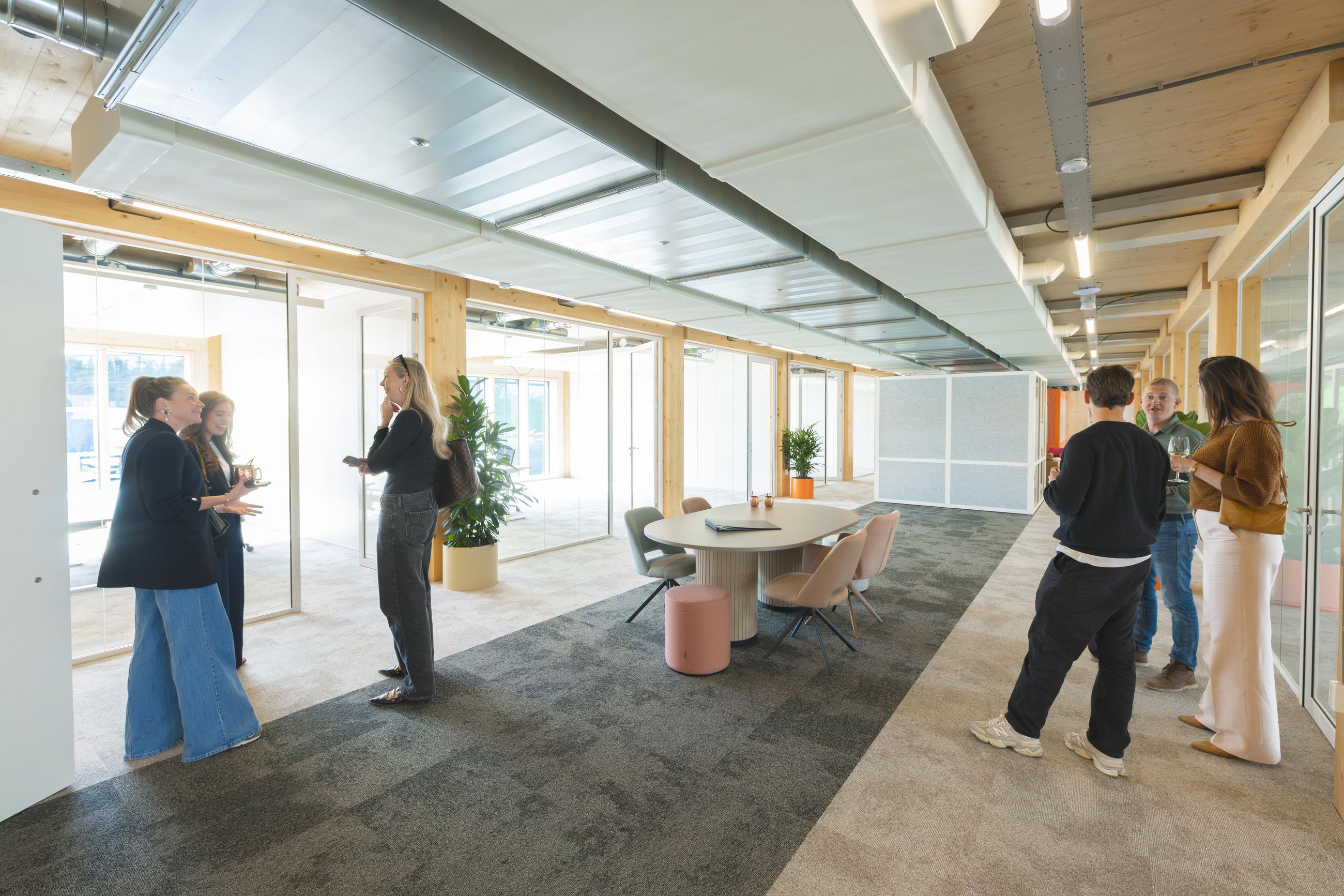 Bezoekers lopen door de open houten werkruimte van Campus Hambaken Timber