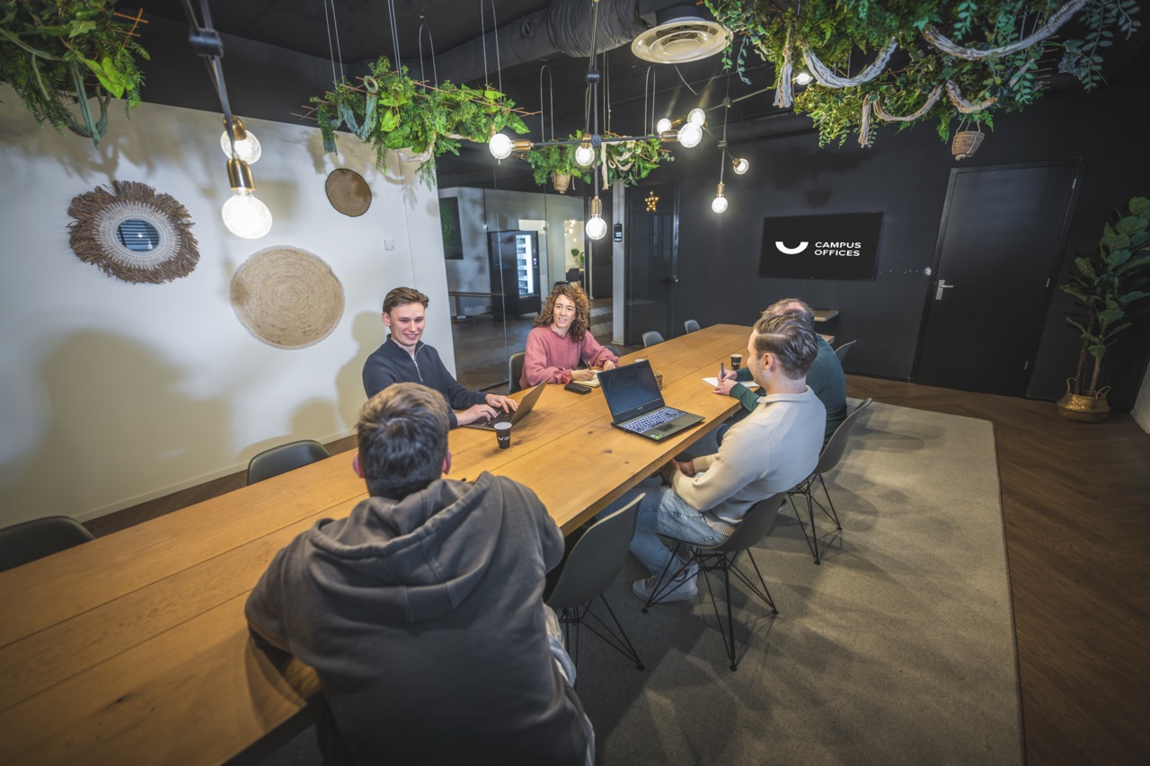 Overleg aan tafel in een vergaderruimte bij Campus Dreesz in Almelo