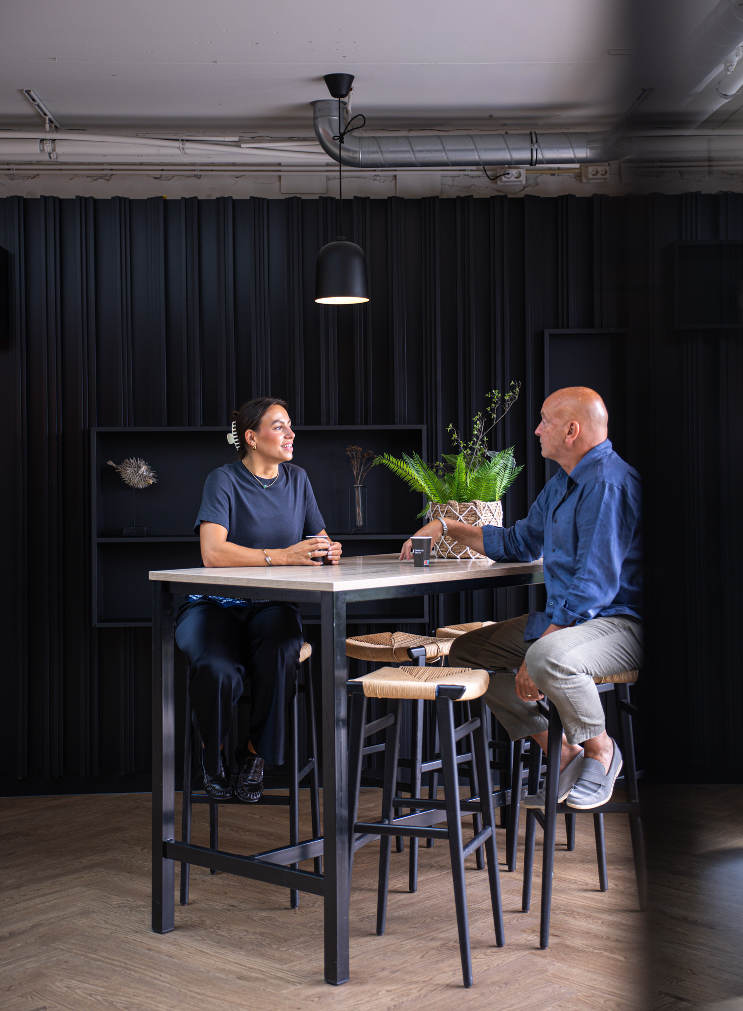Twee mensen in gesprek aan een hoge tafel bij Campus Delta