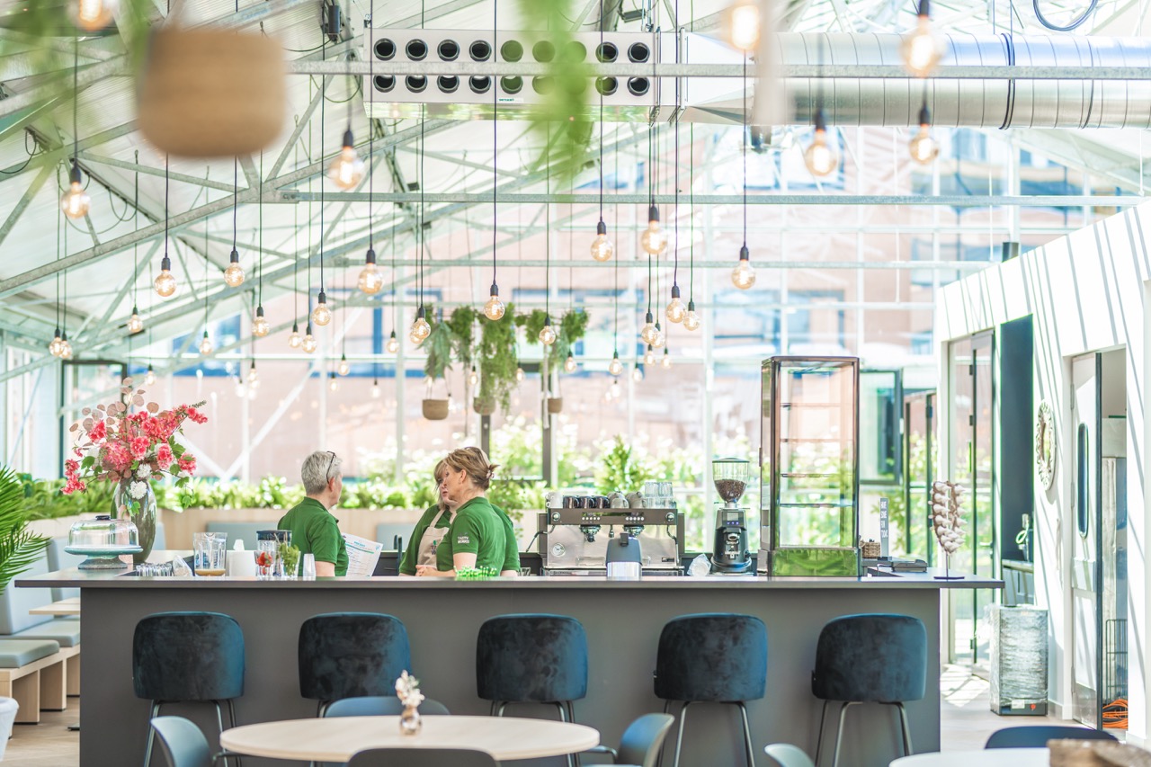 Licht sociaal hart met bar en veel groen bij Campus Seven Cities