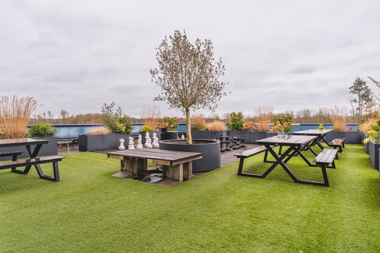 Buitenterras met picknicktafels bij Campus Hambaken in Den Bosch