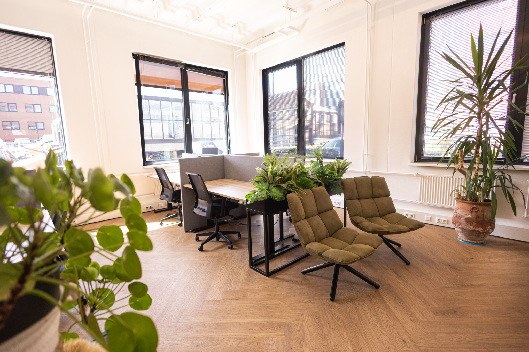 Lichte ruimte met bureaus en stoelen en veel groen bij Campus Seven Cities