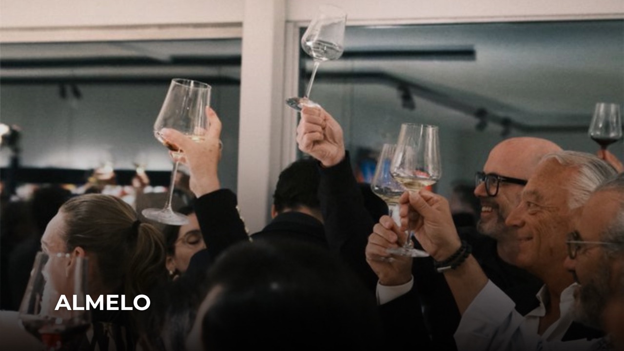 Bezoekers proosten met wijnglazen tijdens een borrel in Almelo