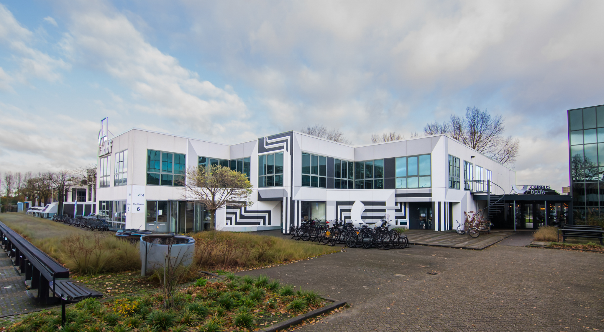 Buitenkant van Campus Delta aan Rietbaan 6 in Capelle aan den IJssel met fietsenstalling en entree.