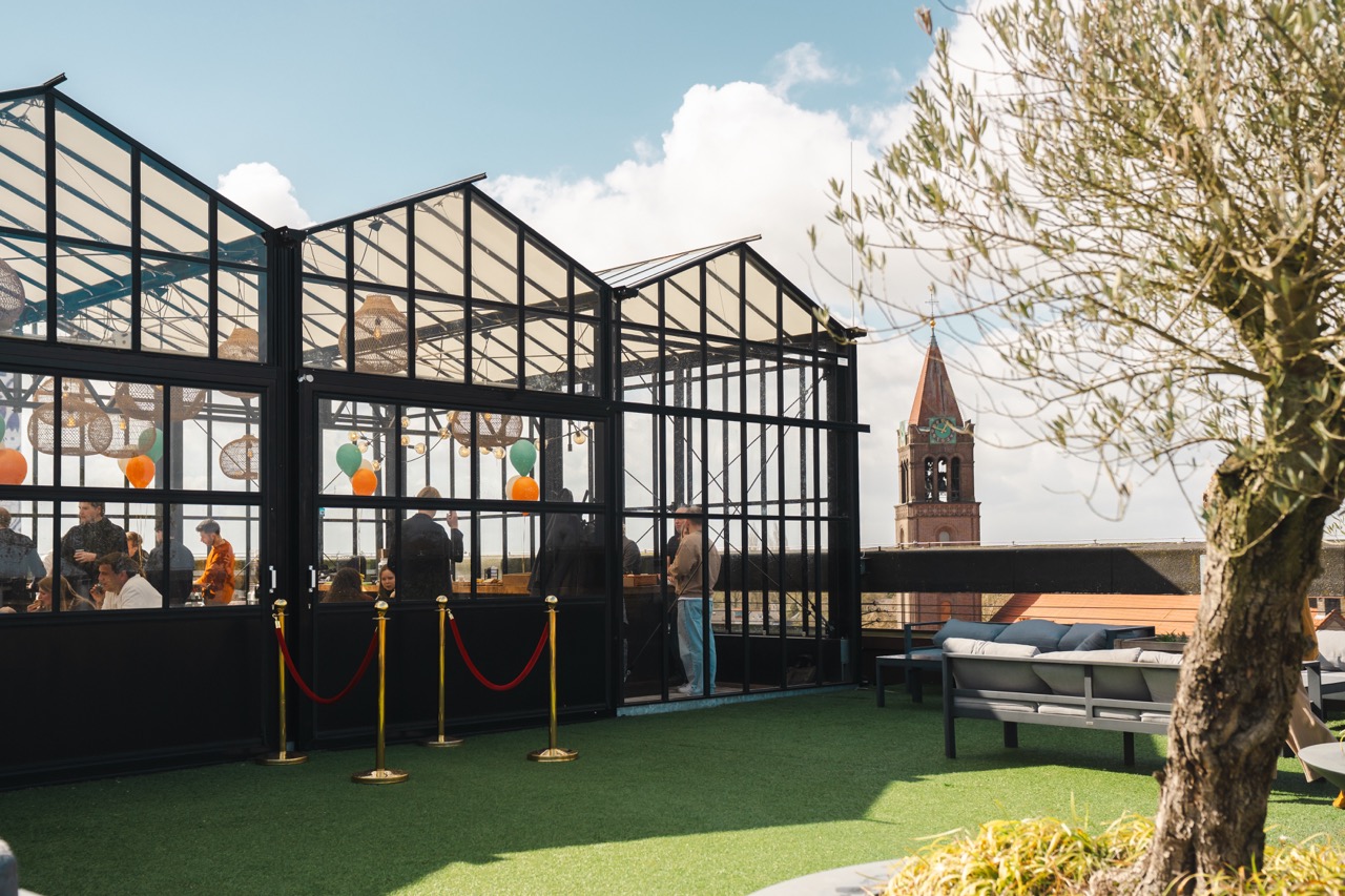 Dakterras met kas bij Campus CeeCee in Roombeek, Enschede met zitplekken en uitzicht op de wijk.