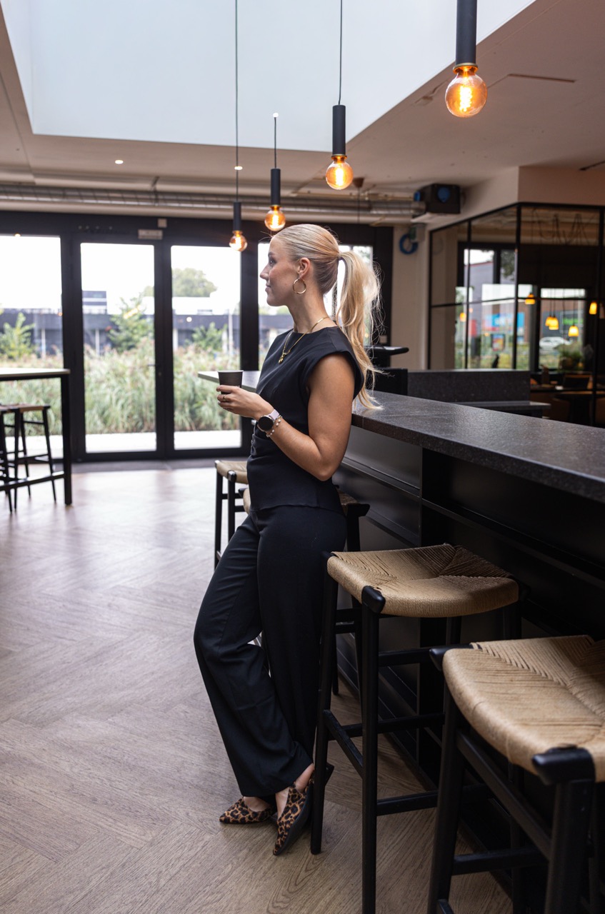 Vrouw met een kopje aan de bar bij Campus Delta.