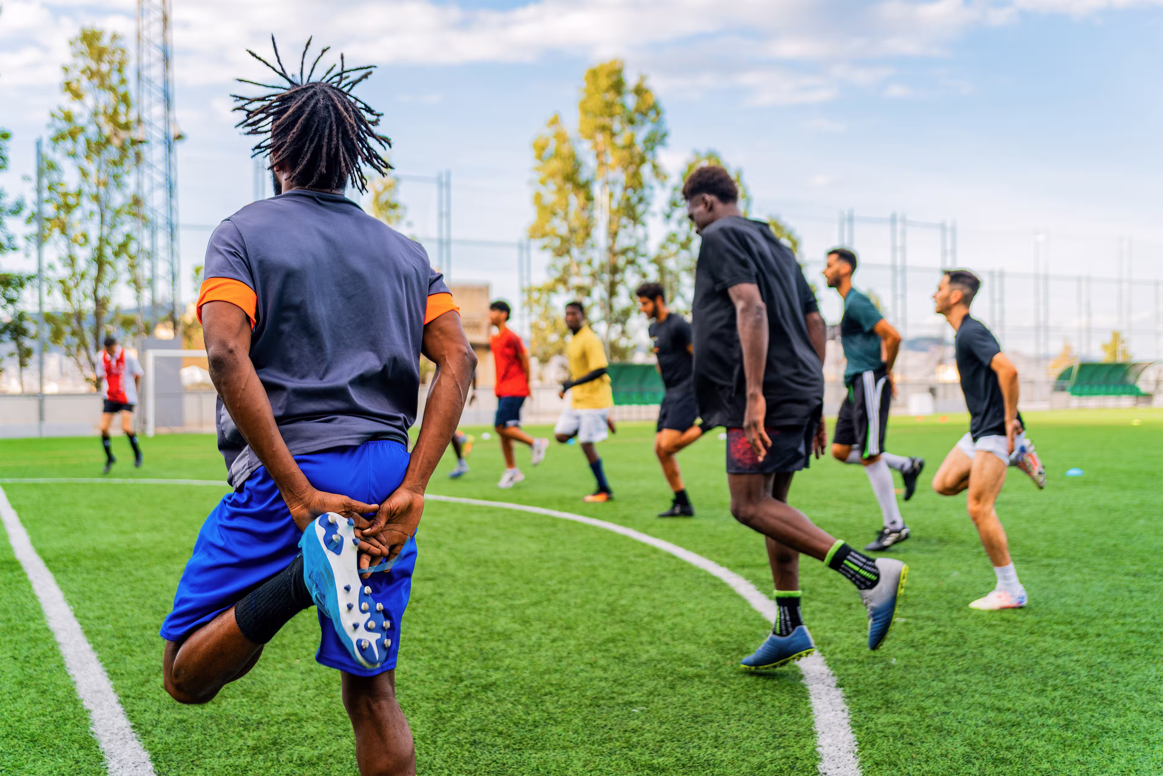 Football players warm up and stretch together