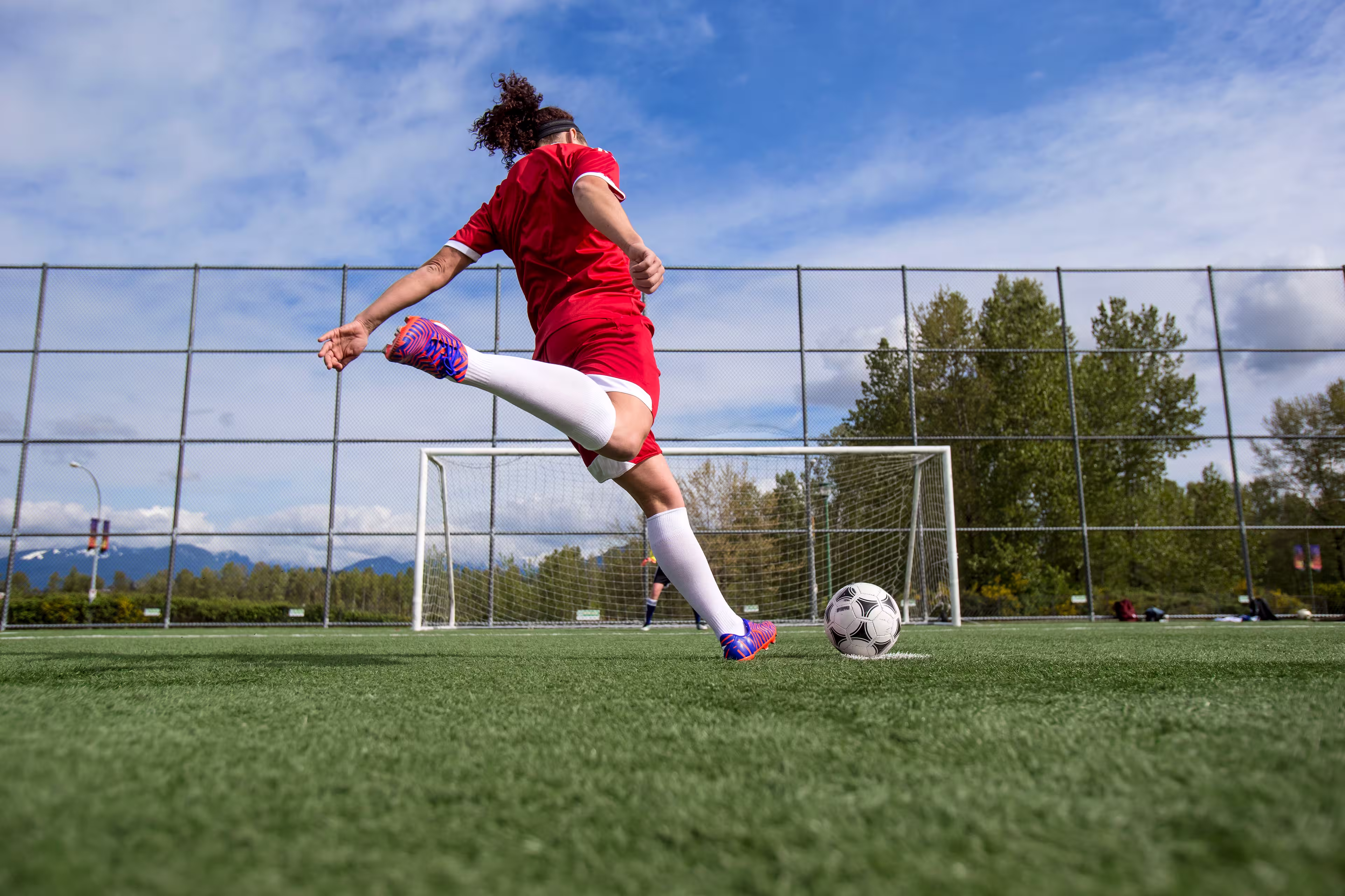 Student-athlete young woman shoots towards empty goal