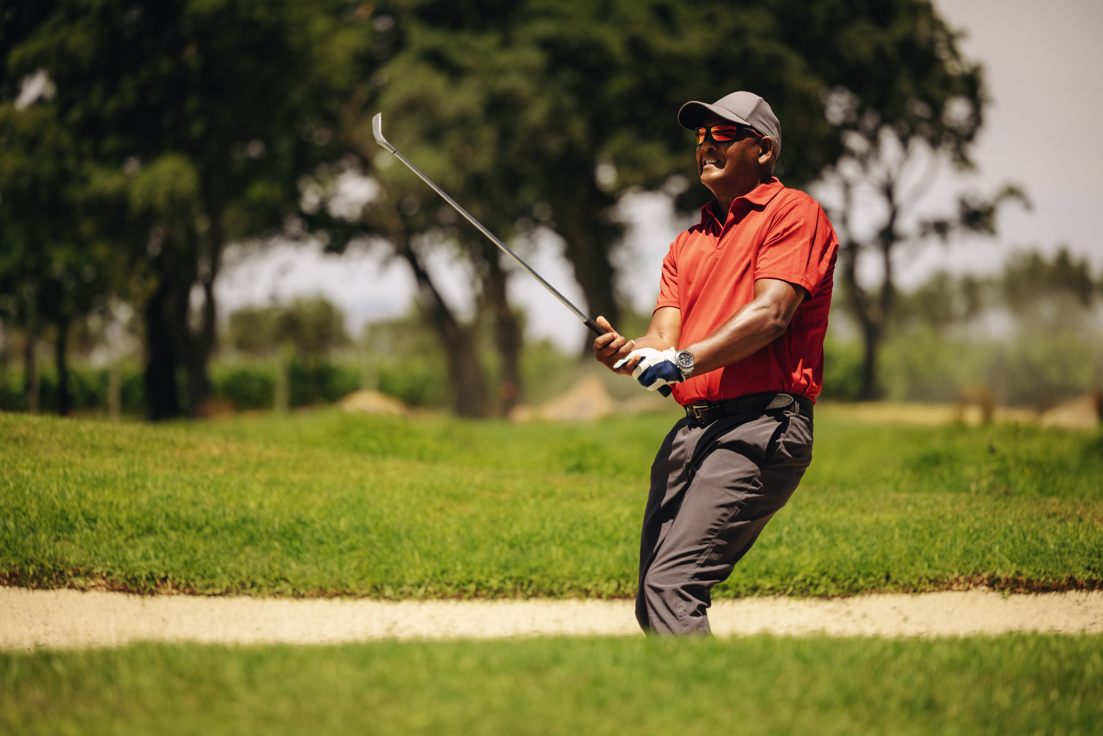 Golfer tries to maintain composure as he struggles to cleanly exit a sand trap