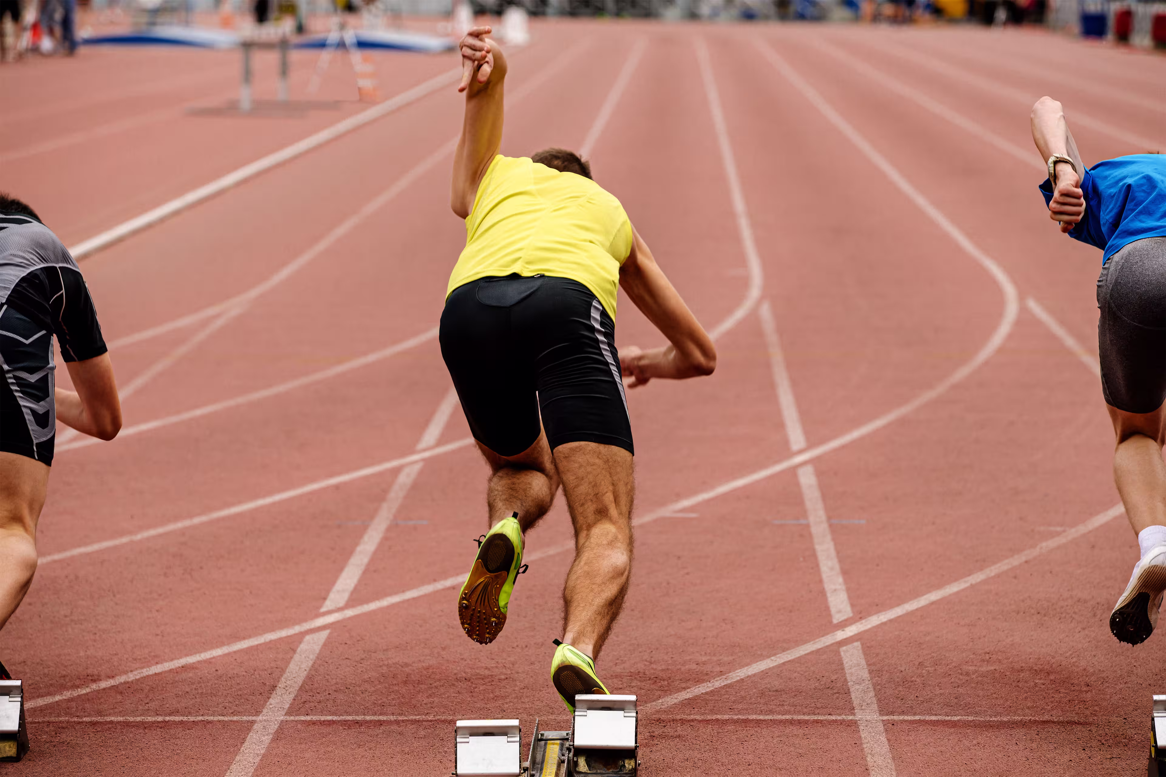 3 sprinters at starting blocks in first seconds of a race