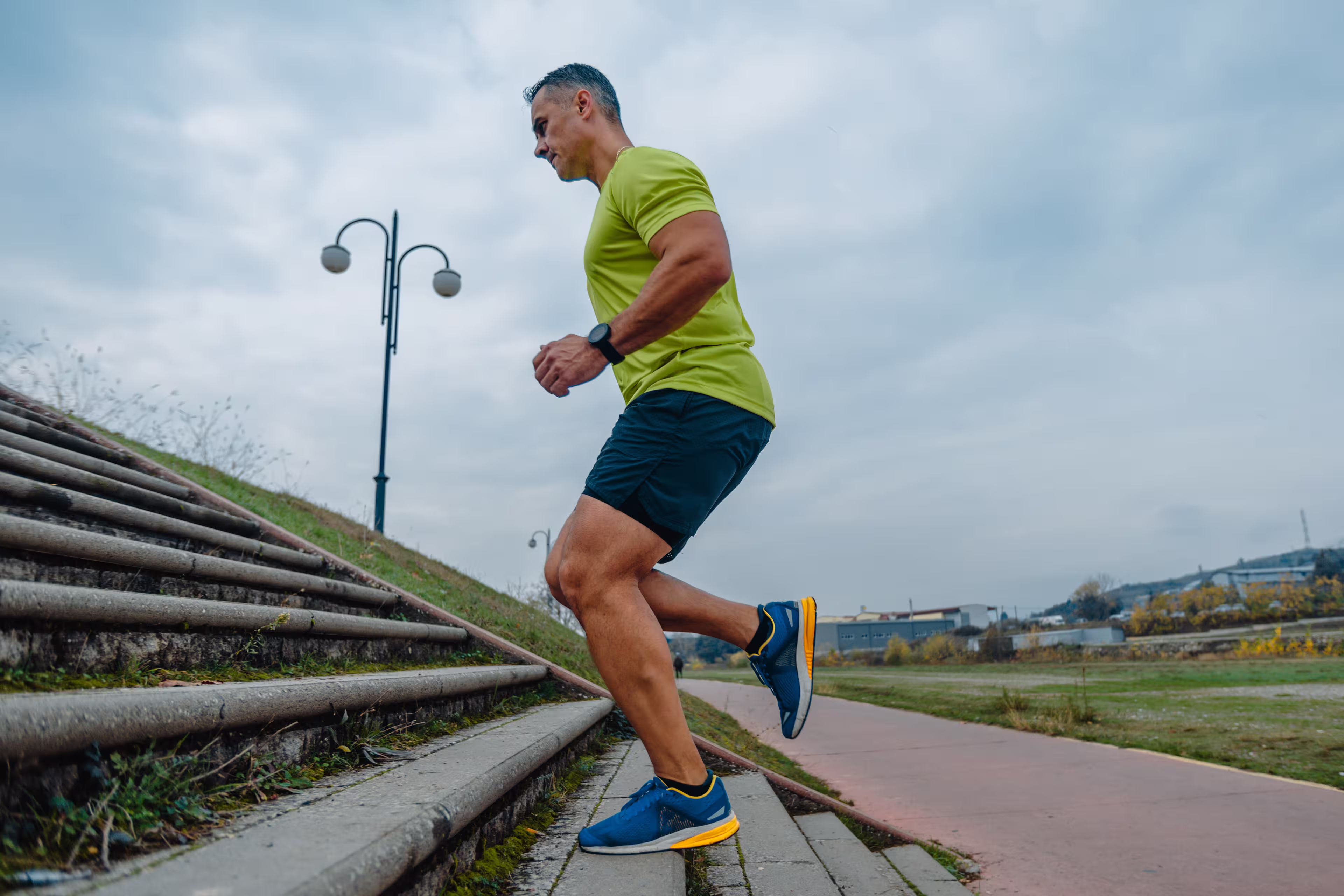 Middle aged man with graying hair running stairs in training session