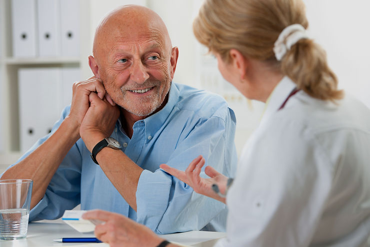 Patient asking a doctor questions during a medical consultation about PET vs CT scans