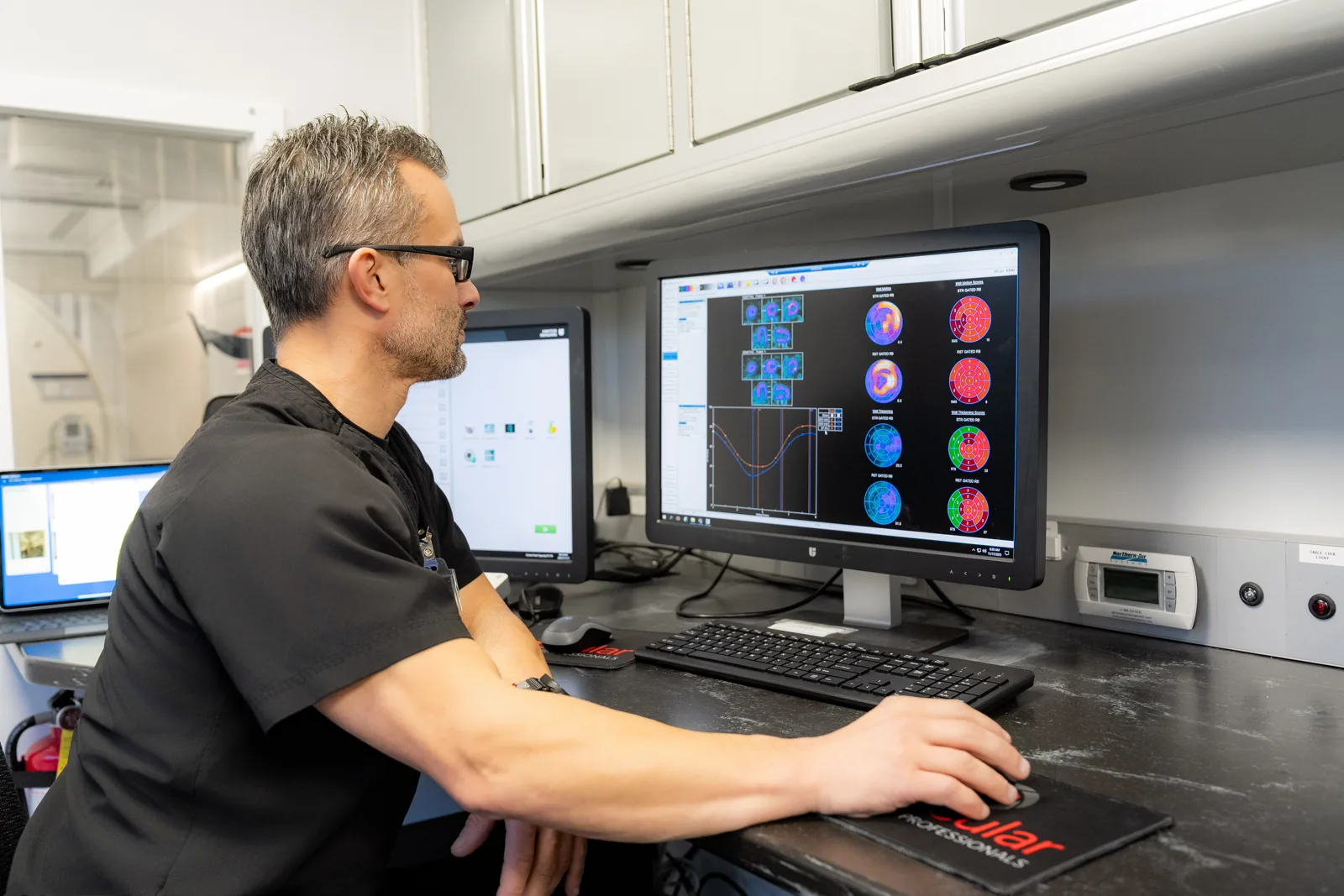 VIP Imaging technologist reviewing cardiac PET perfusion images inside the mobile PET/CT unit serving Los Angeles County practices