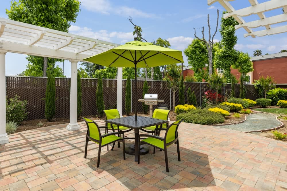 Table and chairs with umbrella with cabana featuring grill