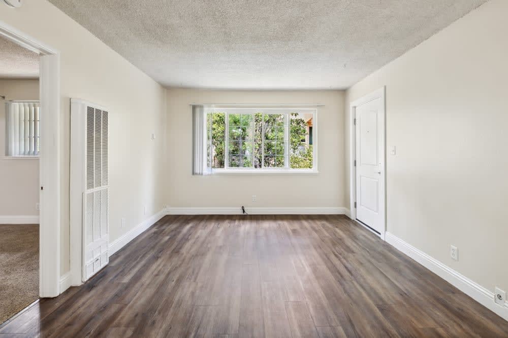Unfurnished living with wood floors and large window