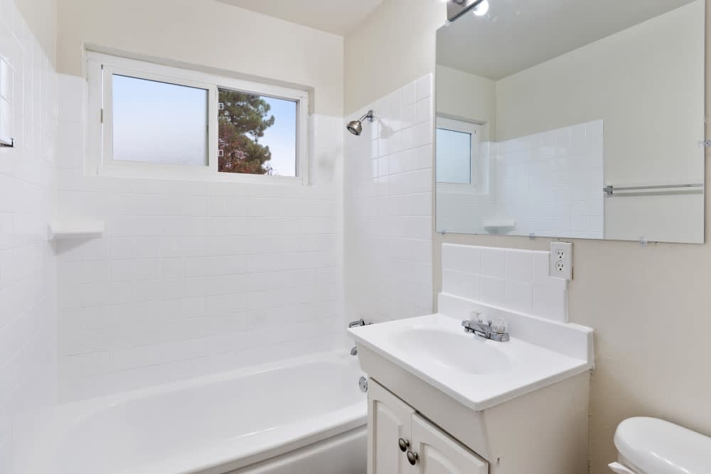 Bathroom with shower tub combo and white cabinets