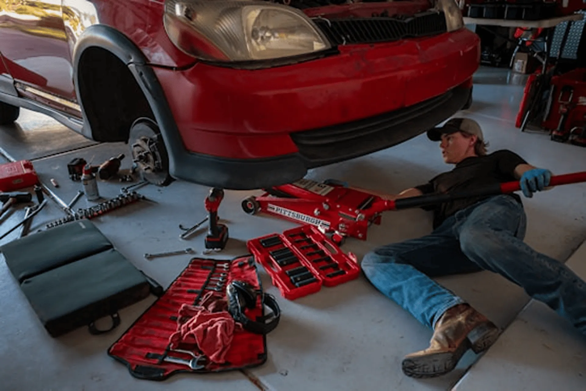 Mann pflegt rotes Auto bei Glanzwerk Autoservice in Kiel