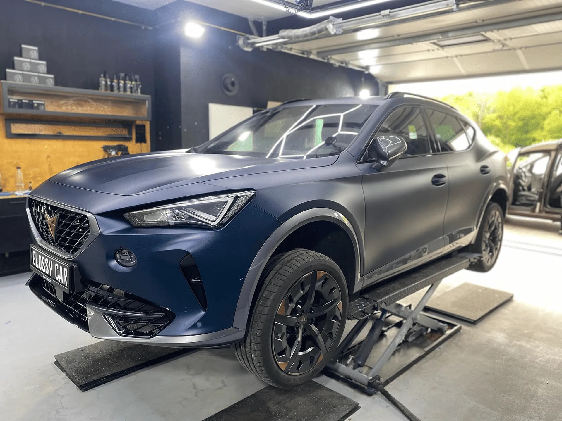Dunkelblauer SUV steht in der Werkstatt von Glanzwerk Autoservice auf einer Hebebühne.