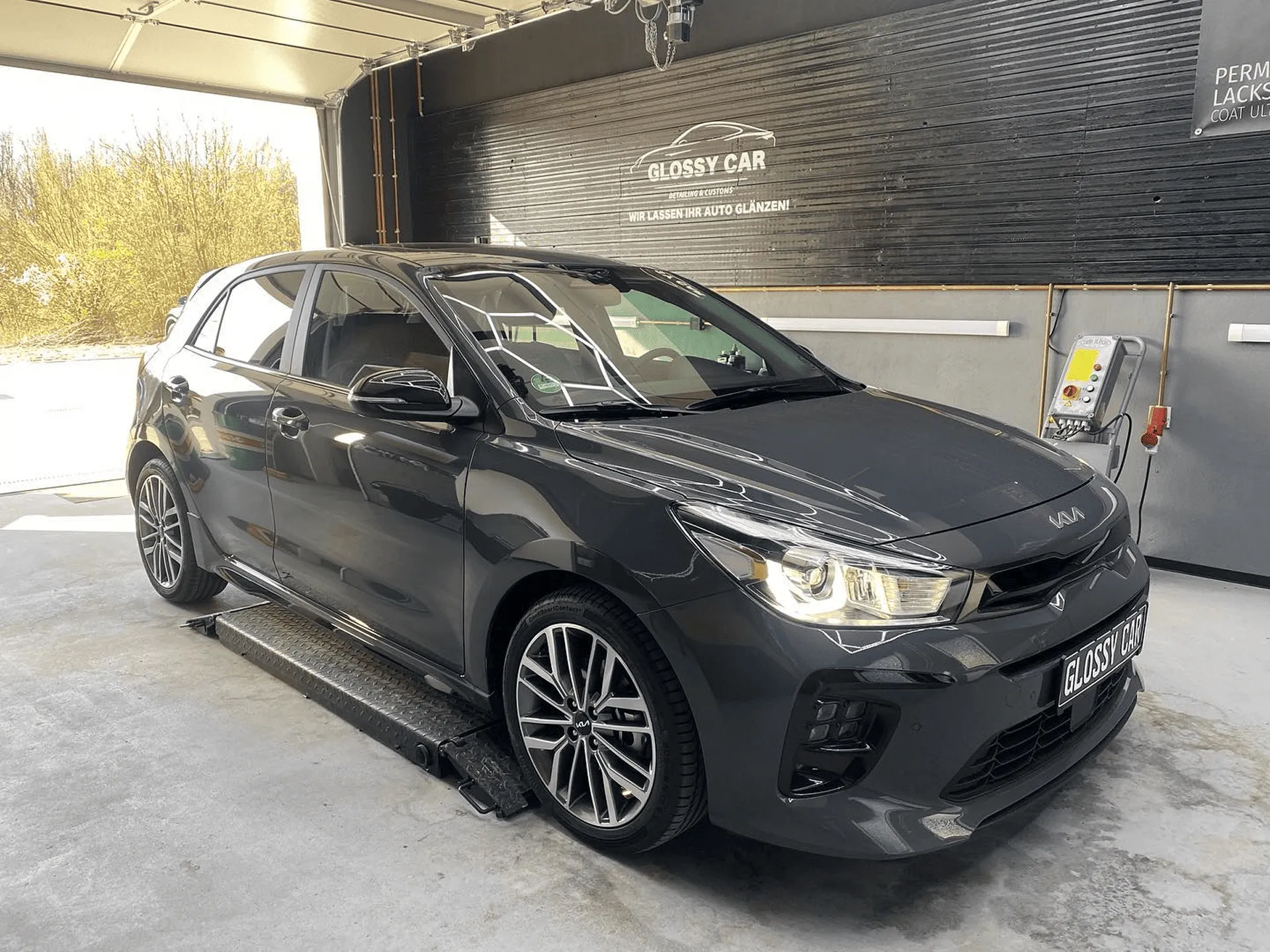 Schwarzer Kia-PKW auf einer Hebebühne in der Werkstatt von Glanzwerk Autoservice.
