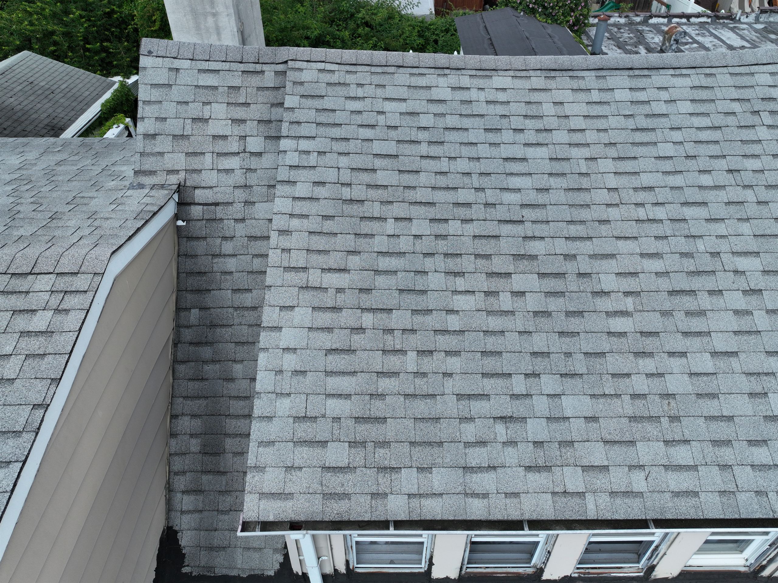 Close-up drone capture from a roof perimeter sweep over a commercial property