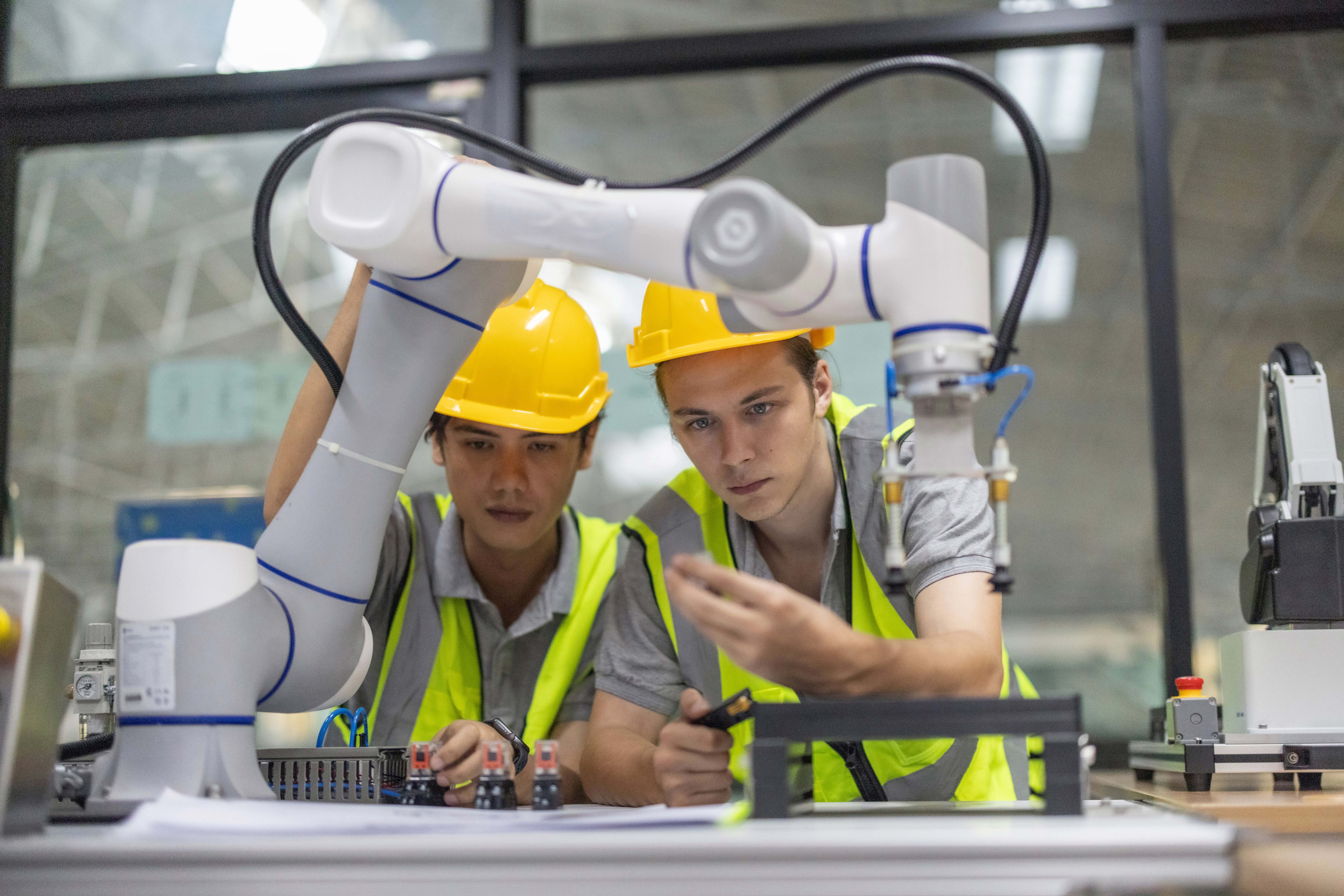 Engineers working alongside collaborative robots in an industrial facility